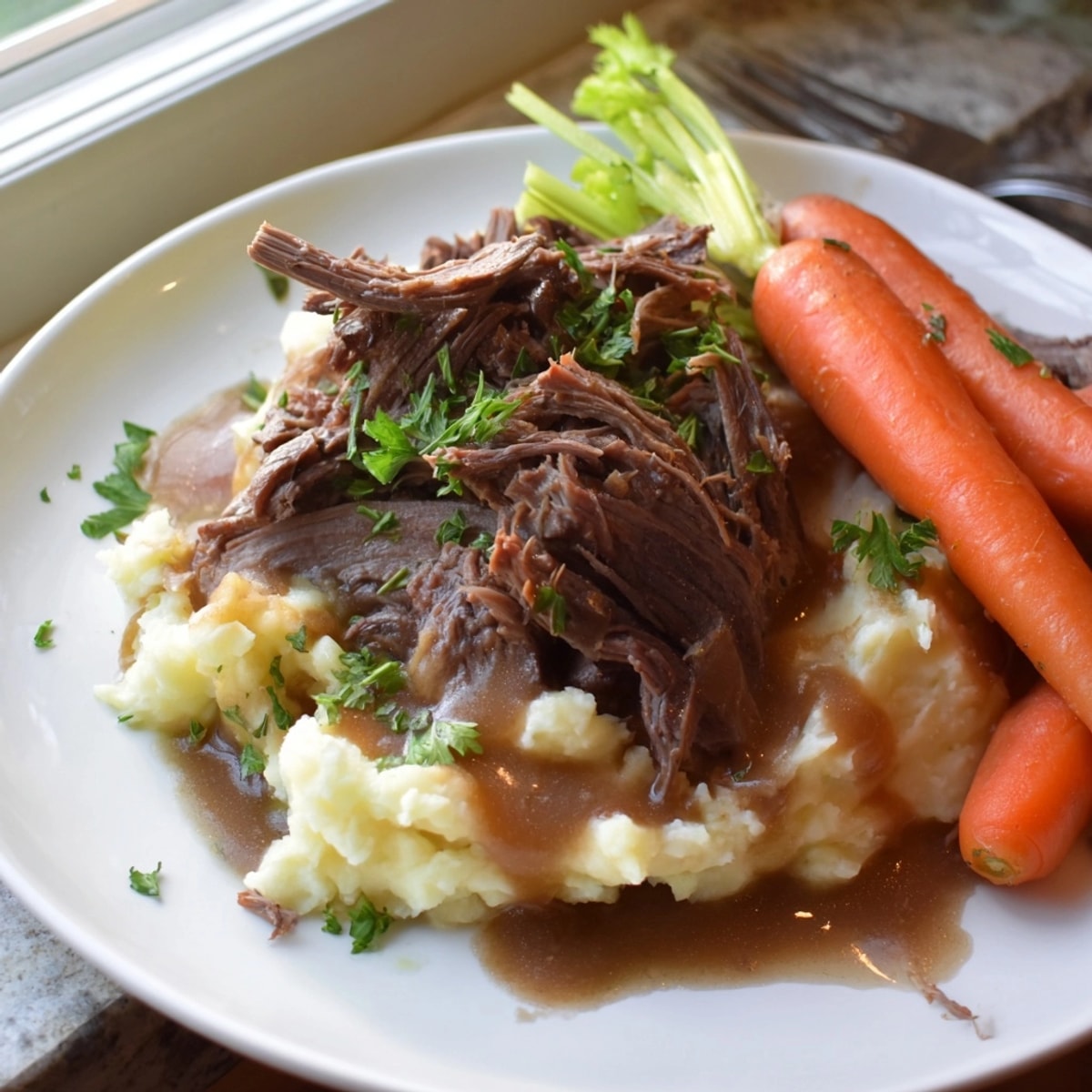 A close-up shows creamy, buttery mashed potatoes topped with savory Slow Cooker Pot Roast.