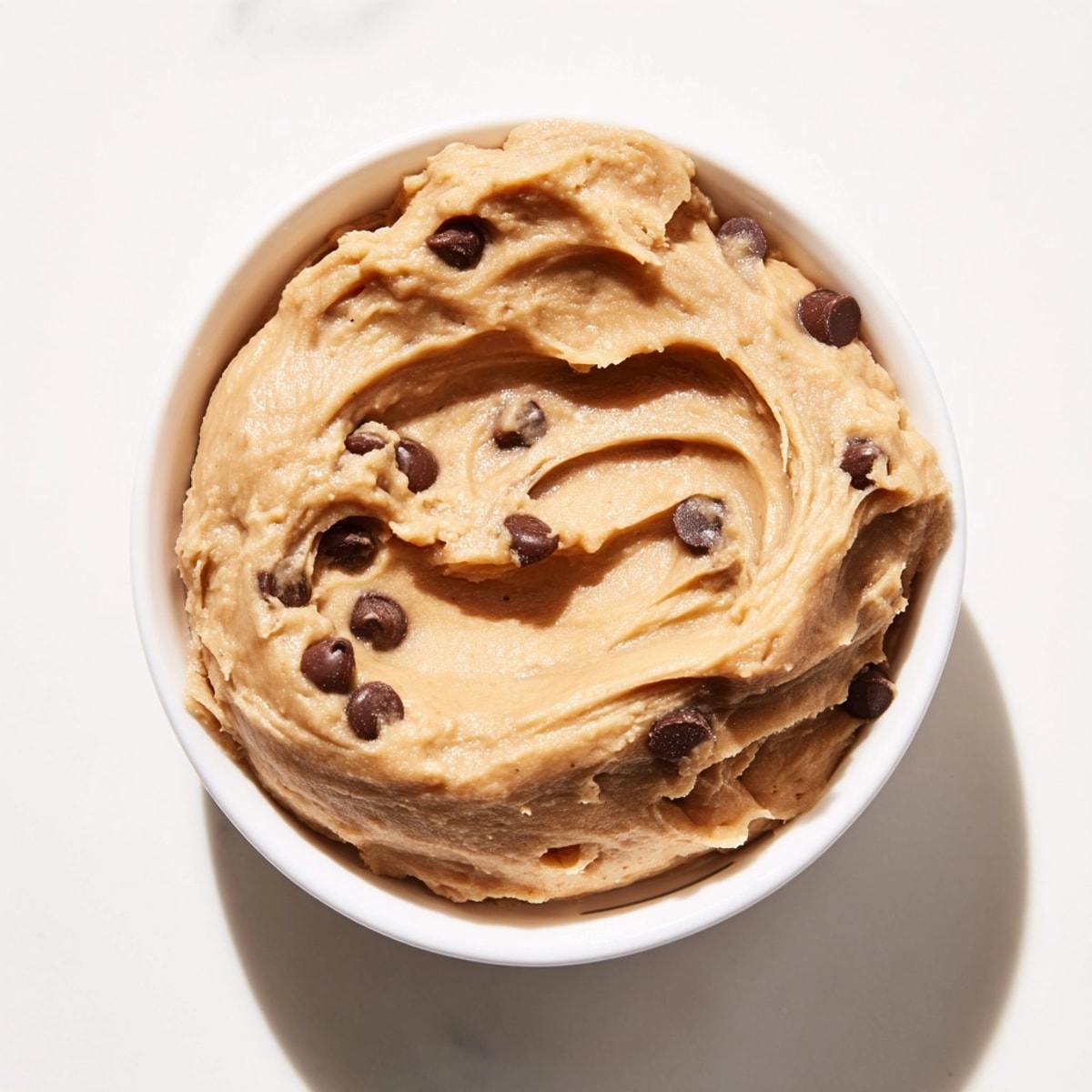 Homemade Chickpea Cookie Dough recipe: a bowl of smooth, vegan treat with melted chocolate swirls.