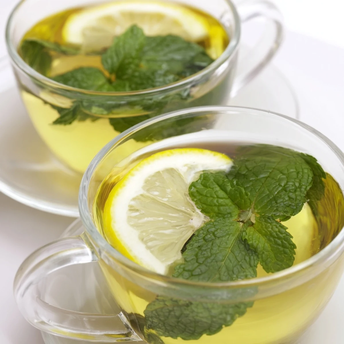 Steaming mug of peppermint tea with fresh mint sprigs, a refreshing herbal delight to savor.