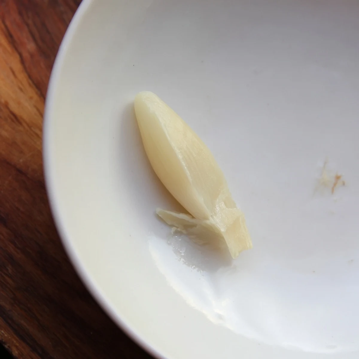 Freshly peeled garlic clove ready for mincing, offering intense flavor to your favorite recipes.