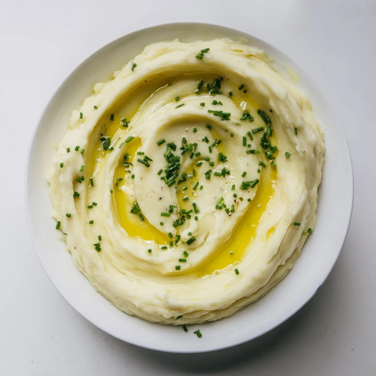 Fluffy Garlic Mashed Potatoes with cream, garnished with fresh chives, ready to serve with dinner.