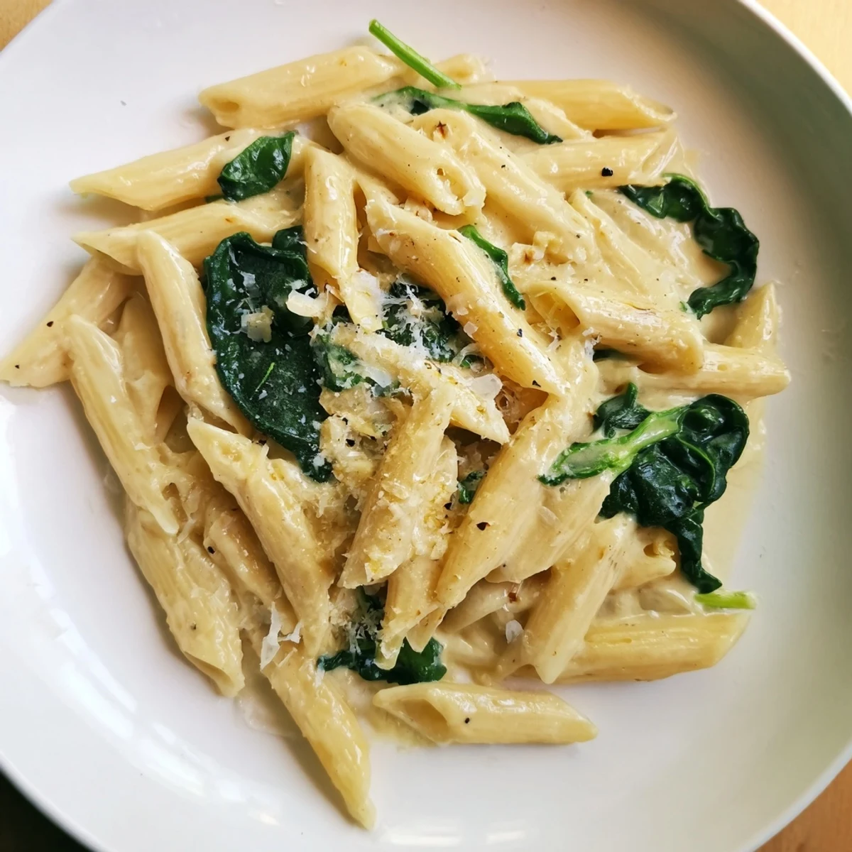 Close-up of Creamy Spinach Pasta, glistening with parmesan and inviting you to savor each bite.
