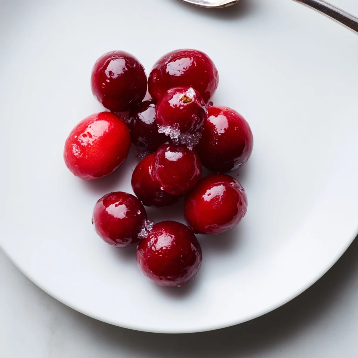 Sweet and ruby-red Garnish Cranberry pieces, nestled on a white plate, perfect for serving.