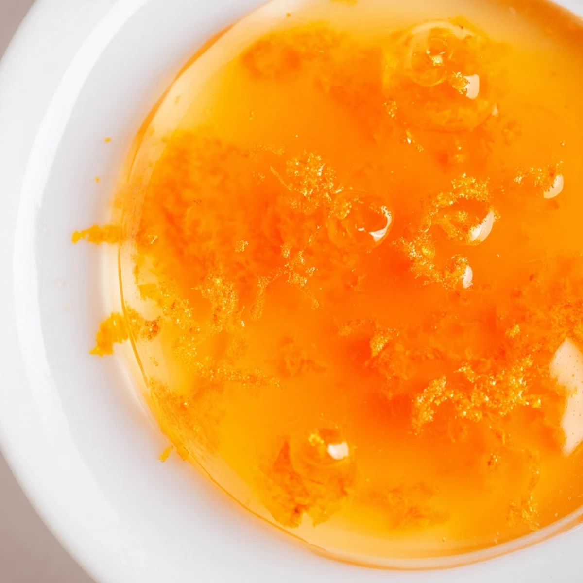 Bright orange and beautifully clear zesty orange jelly, perfect for glazing a cake or enjoying on scones.