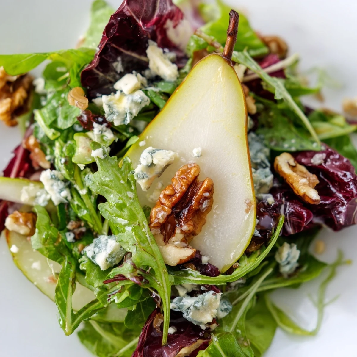 Chopped walnuts coated in sparkling sugar add a sweet crunch to the vibrant Winter Green Salad with Pear and Candied Walnuts, arranged on a rustic platter.