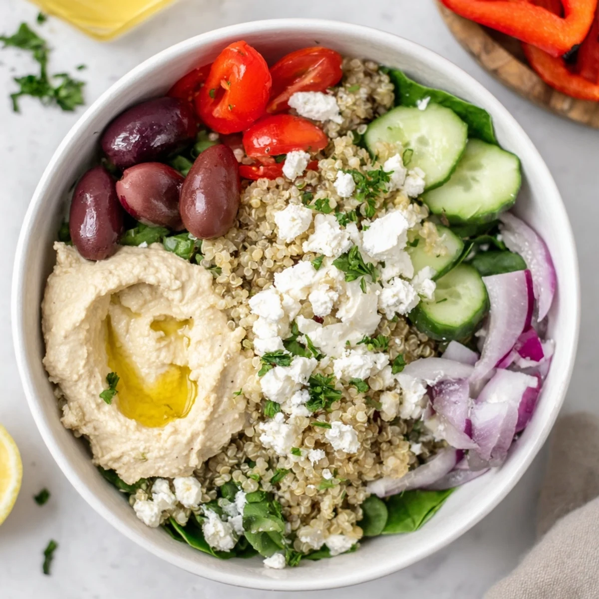 Close-up of a Mediterranean Quinoa Bowl showing fluffy quinoa, sliced roasted red peppers, and crisp greens ready to be devoured.