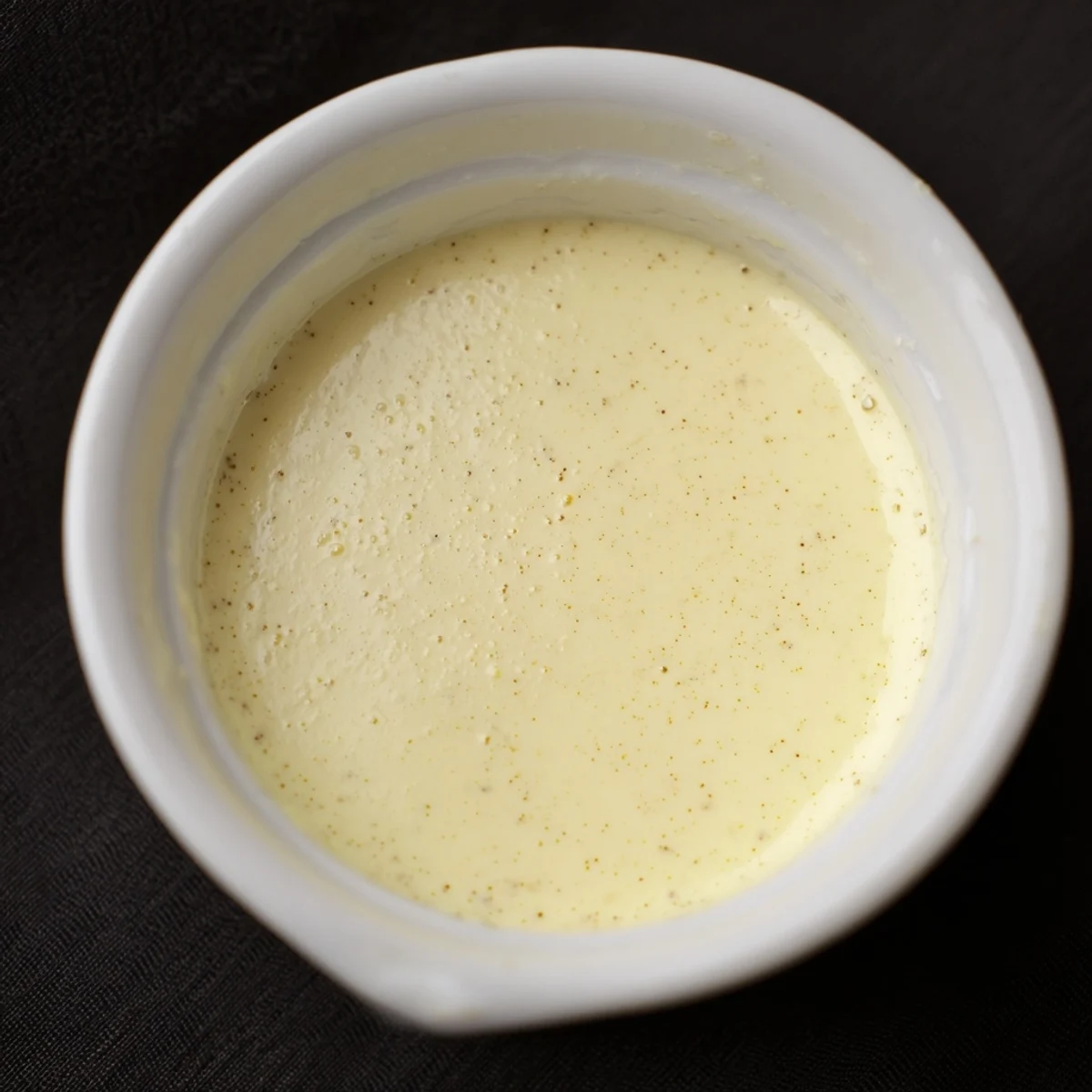 Silky Creamy Custard with Vanilla wobbling gently in a ramekin, paired with a golden shortbread cookie on a rustic wooden table.