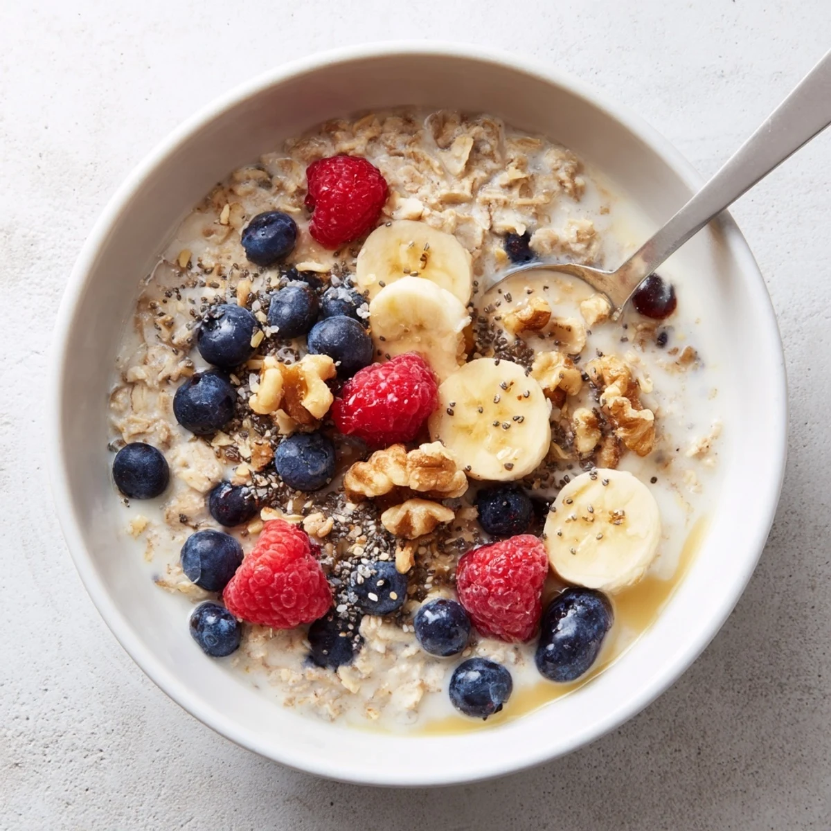 A cozy spoonful of Creamy Breakfast Oats garnished with chia seeds and berries for a nourishing start.