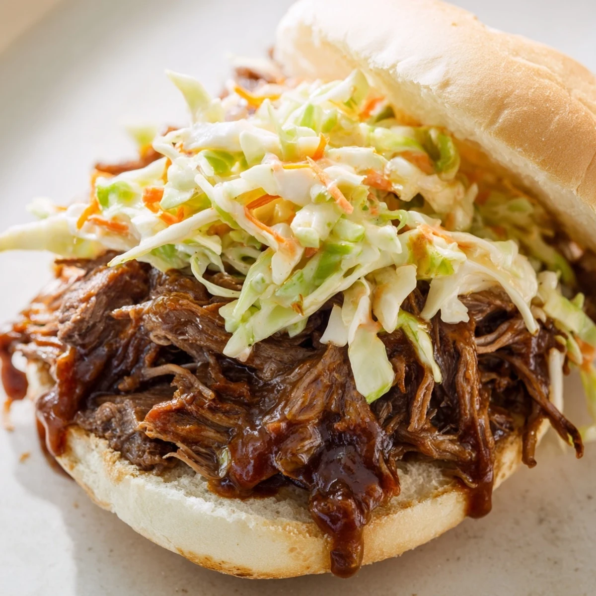 Slow Cooker Pulled Beef Sandwiches stacked high with tender beef and creamy coleslaw on soft buns.