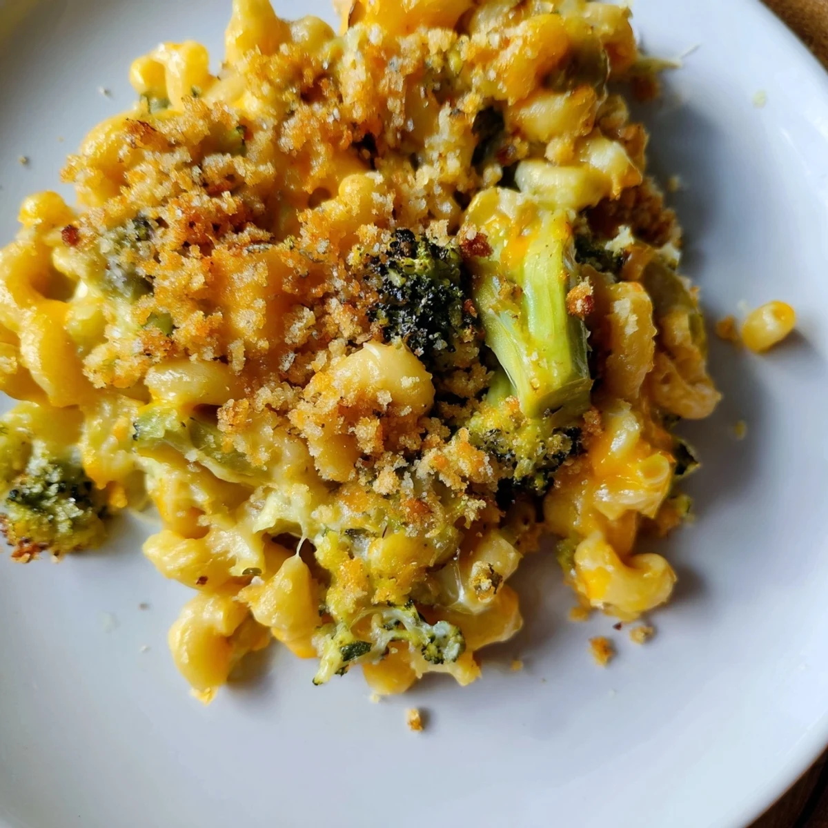 Freshly baked macaroni and cheese with roasted broccoli served on a white plate, perfect family dinner.
