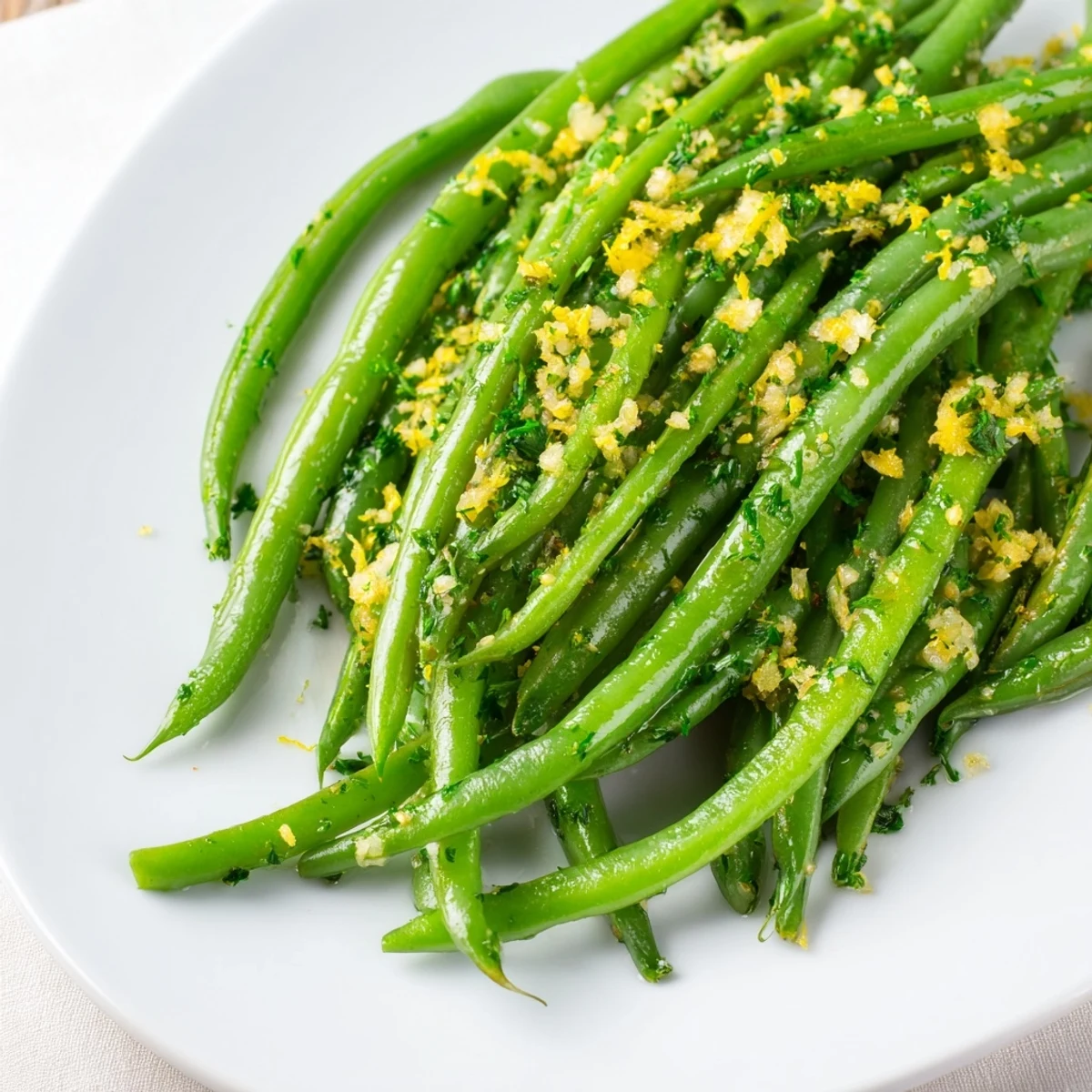 On a rustic wooden table, Lemon Green Beans with Minced Garlic are garnished with parsley and lemon wedges.