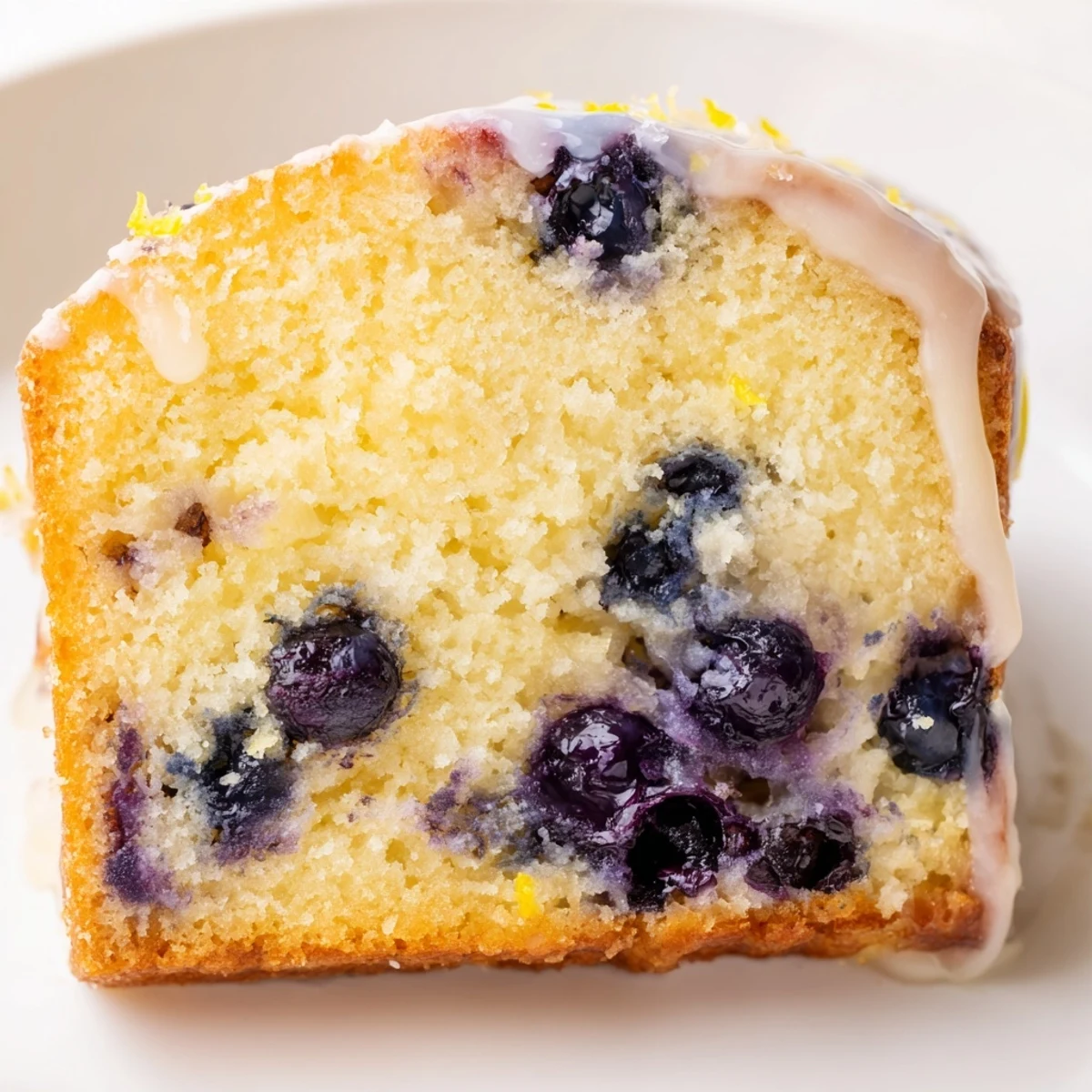 Sliced Lemon Blueberry Cake showing tender crumb and bursts of juicy blueberries, ready for serving.  