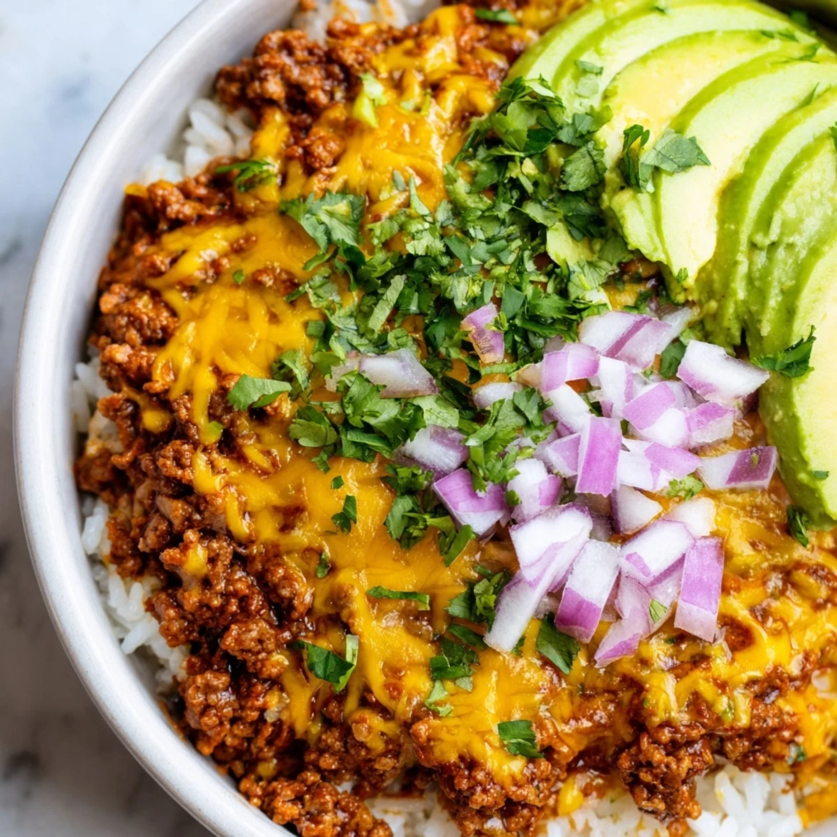 A vibrant Beef Burrito Bowl with seasoned ground beef, cilantro-lime rice, black beans, corn, and fresh toppings like avocado and sour cream.