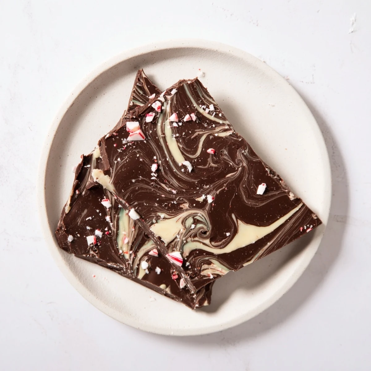 A close-up of homemade mint chocolate bark with crushed candy canes and marbled white chocolate.