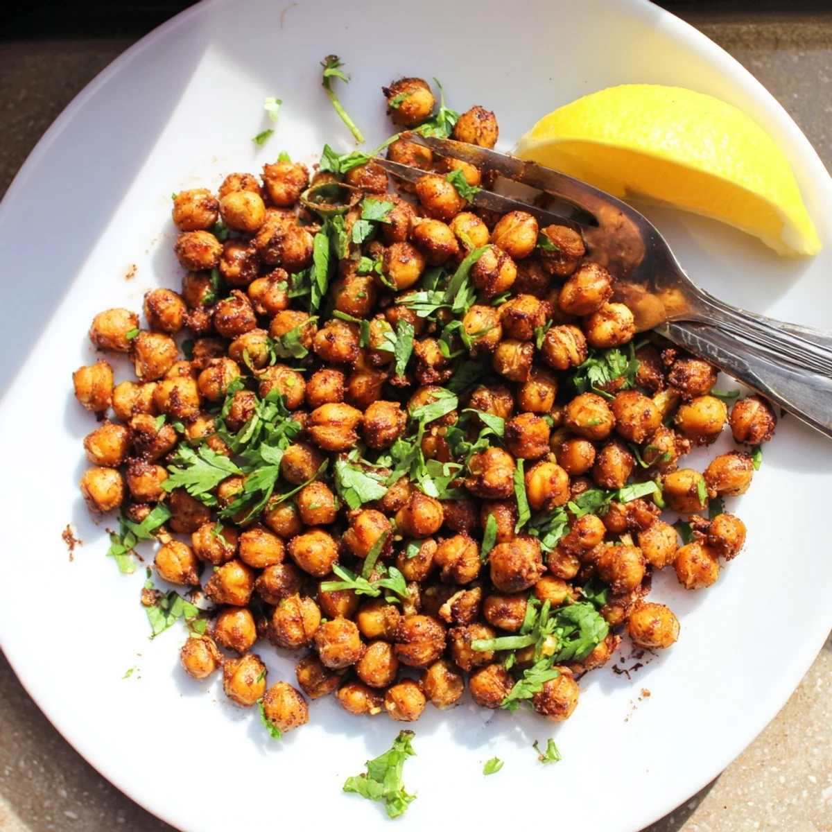 Freshly roasted Spicy Roasted Chickpeas with Cumin glisten with olive oil and spices, ready to be enjoyed as a crunchy salad topper or appetizer.