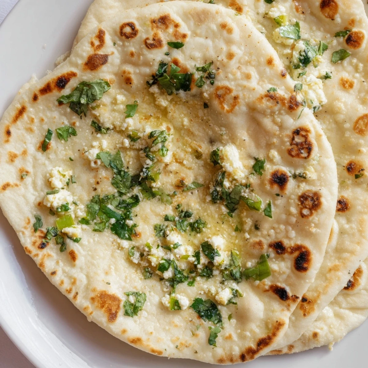 In this Cottage Cheese Garlic Naan, soft flatbread layers reveal creamy filling for an authentic Indian meal.