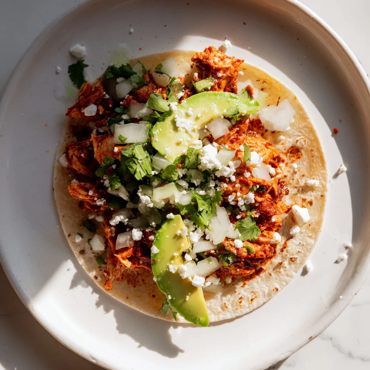 Golden-brown grilled chicken pieces rest on warm corn tortillas, topped with diced white onion, fresh cilantro, and creamy avocado slices in Chicken Street Tacos.