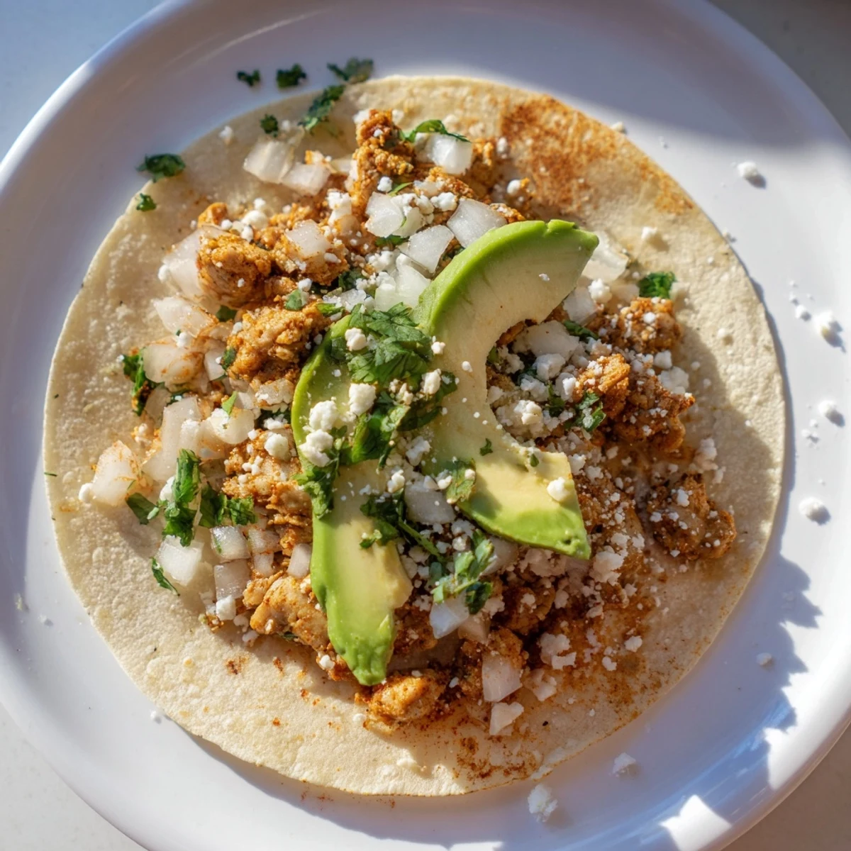 Freshly prepared Chicken Street Tacos feature tender chicken, chopped cilantro, and diced onions inside soft tortillas, served on a rustic wooden table.