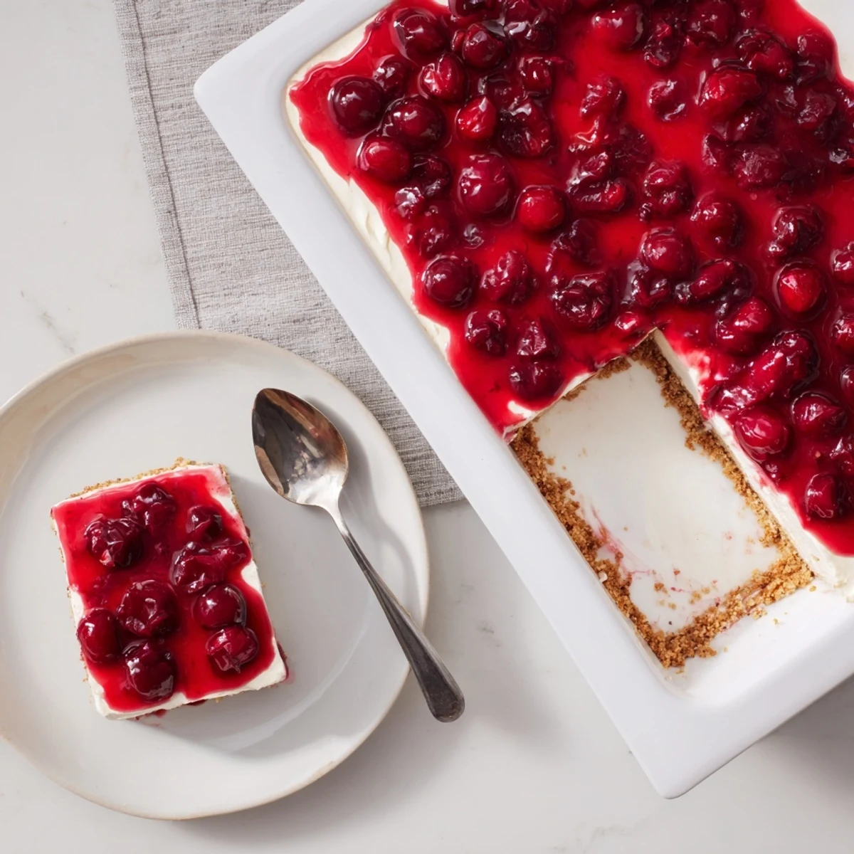 No-bake Classic Cherry Delight with spoonable cherry topping, served cold on a simple white plate.