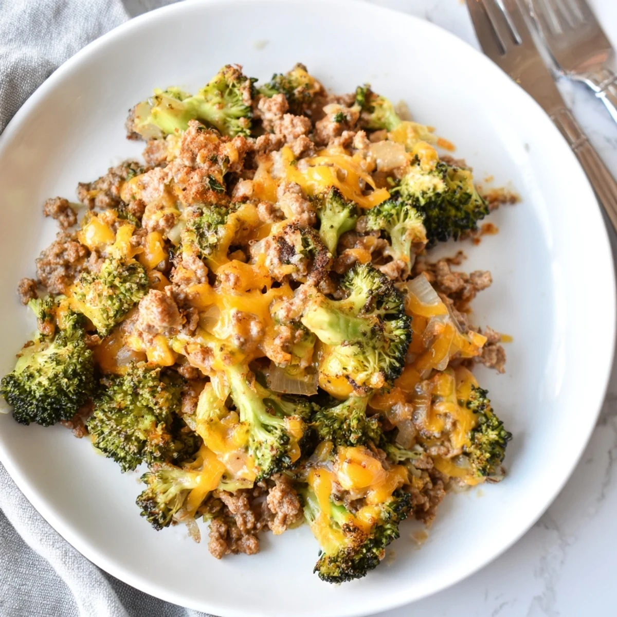 Golden melted cheddar blankets seasoned ground beef and vibrant green broccoli florets in a hot Keto Hamburger Broccoli Skillet.