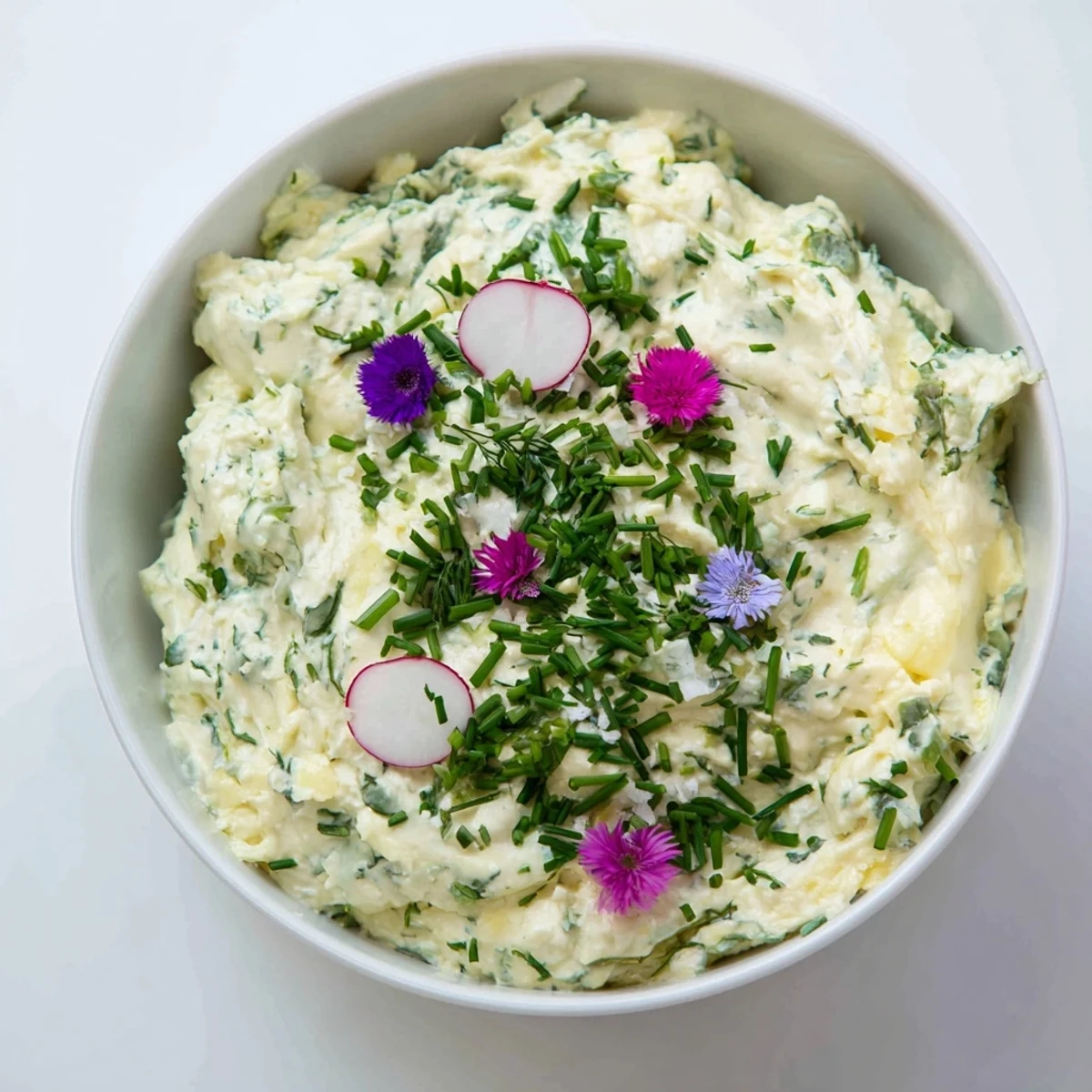 Simple Easter Herb Cheese Dip in a festive serving dish, surrounded by radish slices and fresh herb sprigs.