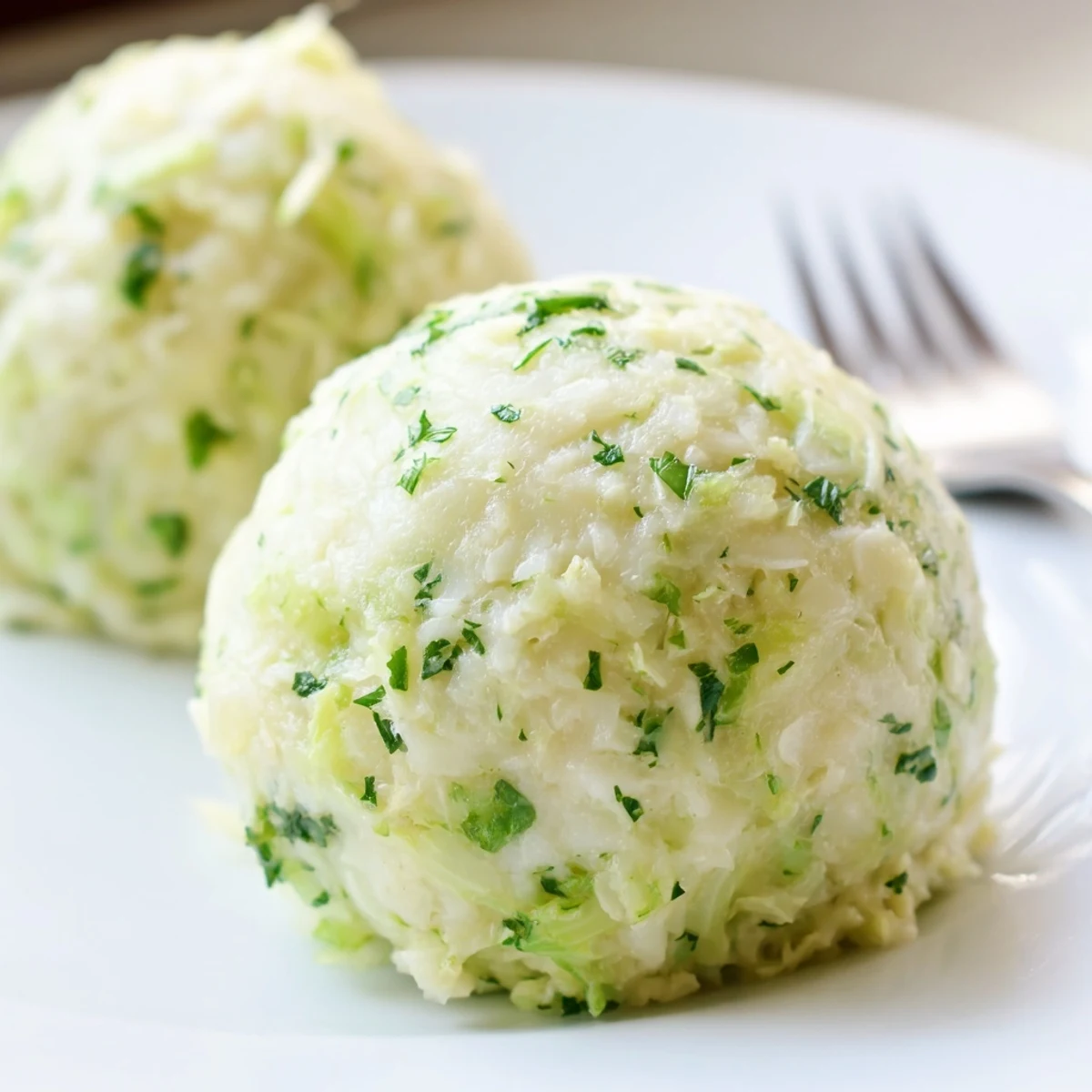 Steaming German Cabbage Dumplings on a plate, garnished with fresh parsley and ready to serve.