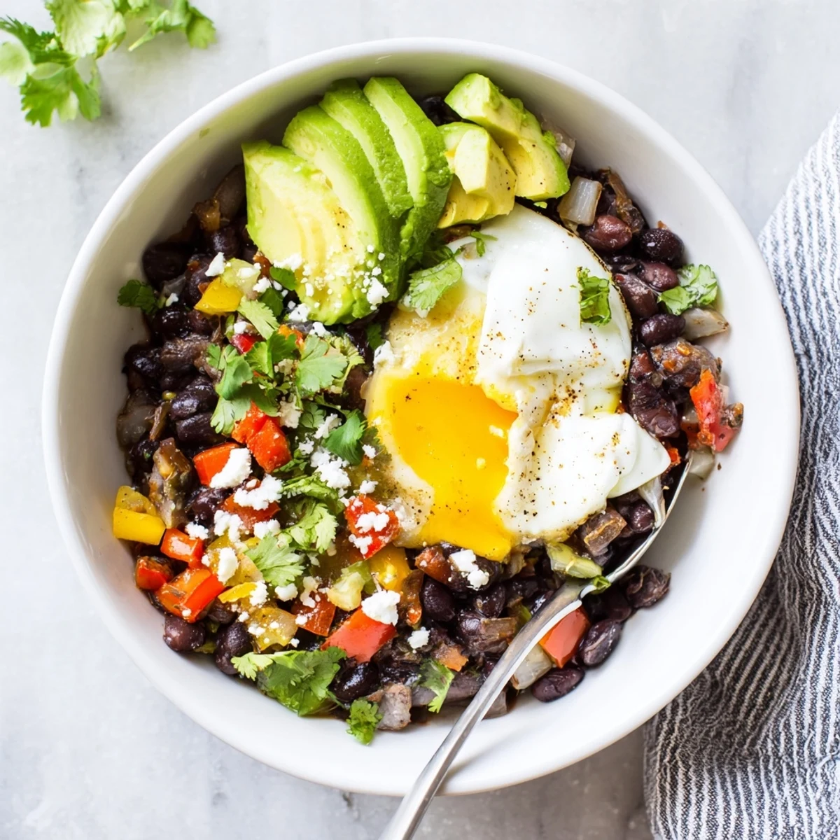 Warm and comforting Mexican Braised Beans With Soft Boiled Egg served with lime wedges and crumbled queso fresco.