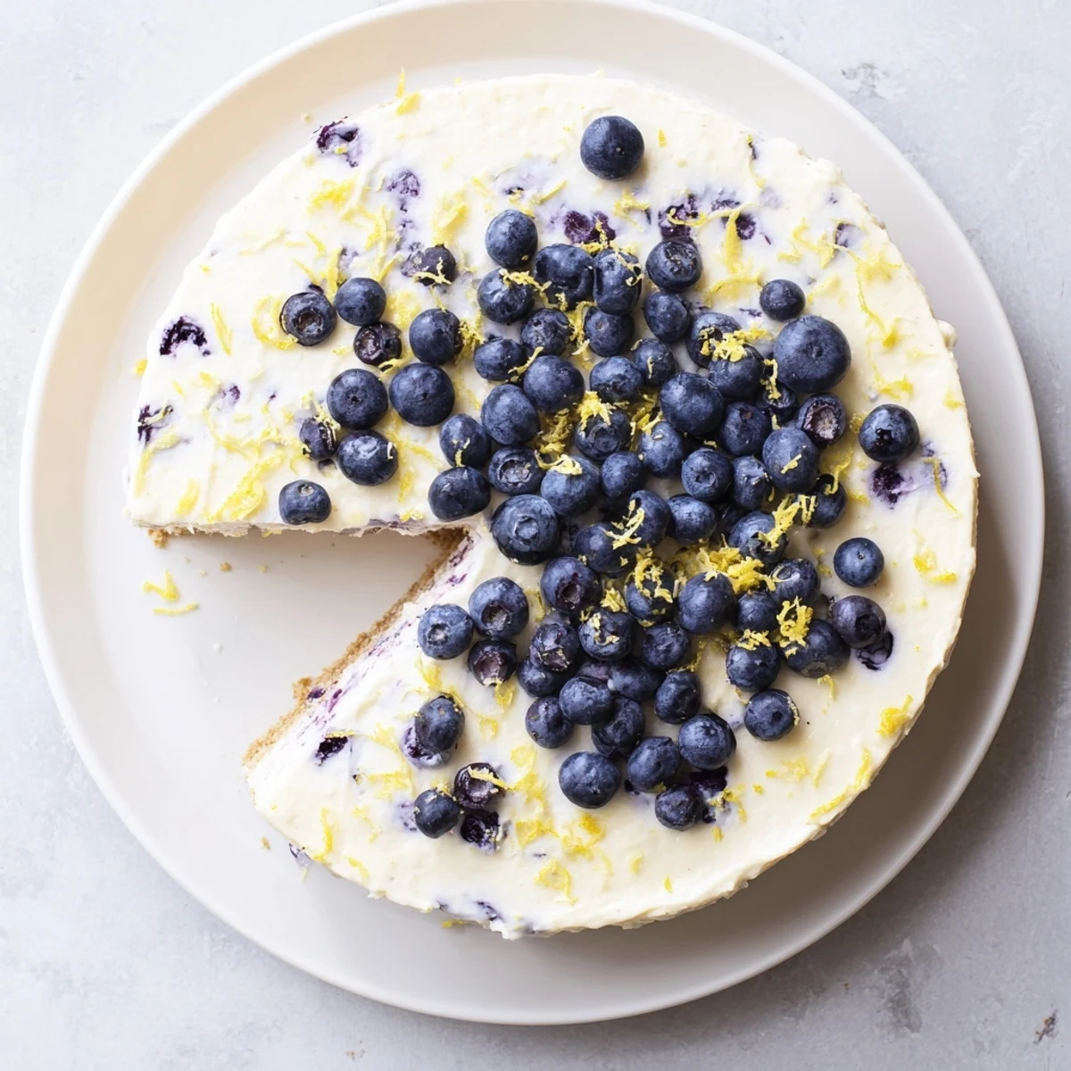 Fresh slices of no bake lemon blueberry cream cake show creamy layers and bright berries on a summer dessert table.