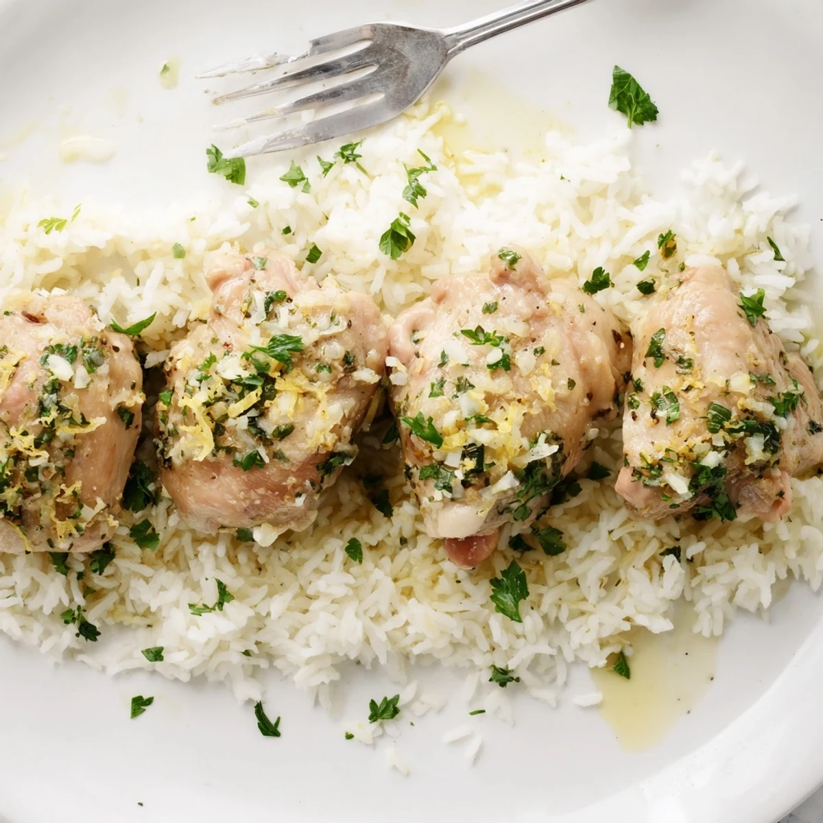 Tender Slow Cooker Lemon Herb Chicken With Fluffy Rice garnished with parsley on a rustic wooden table.