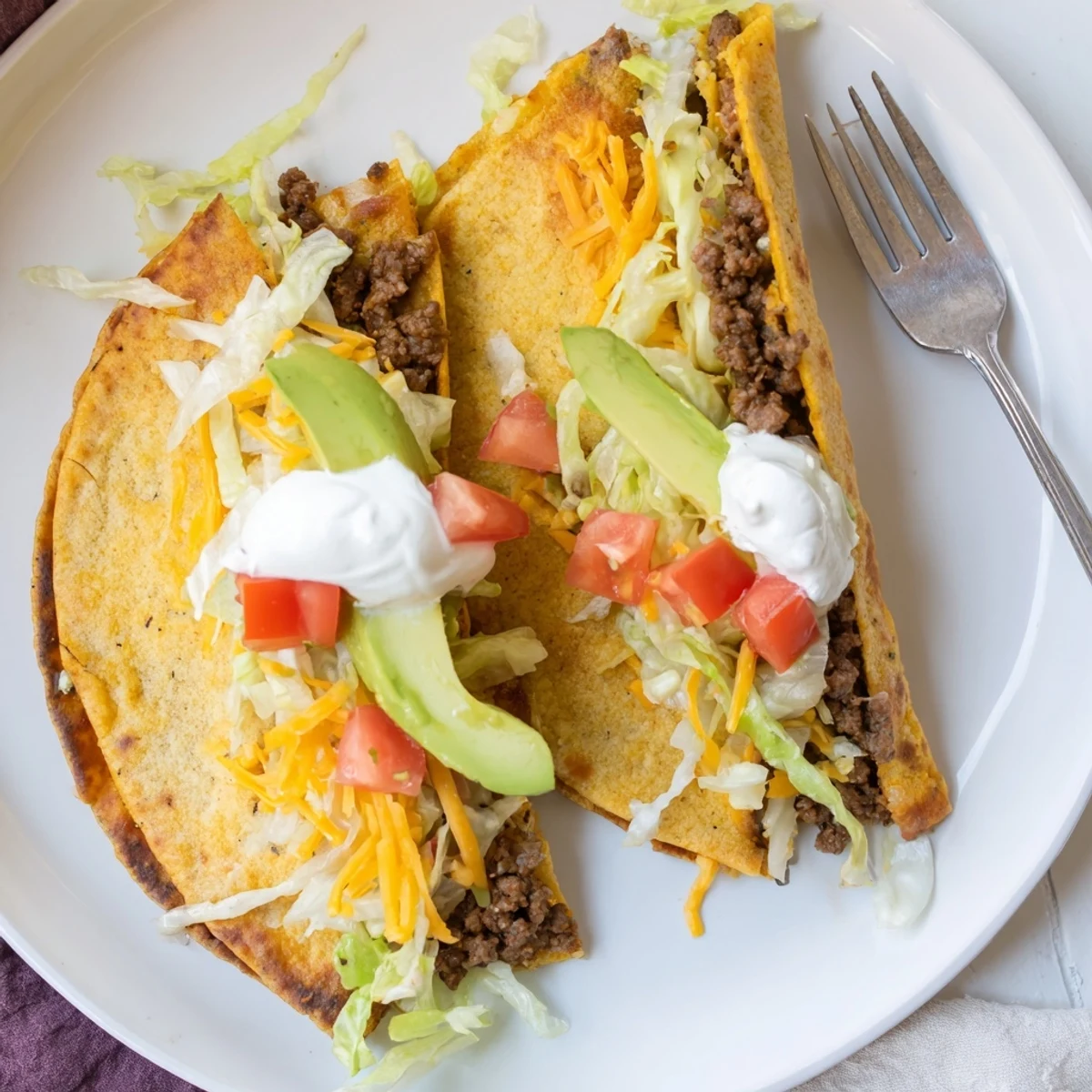 Sliced keto crunchwrap revealing a mouthwatering cross-section of taco-seasoned beef, crisp vegetables, and gooey cheese nestled in a warm golden wrap