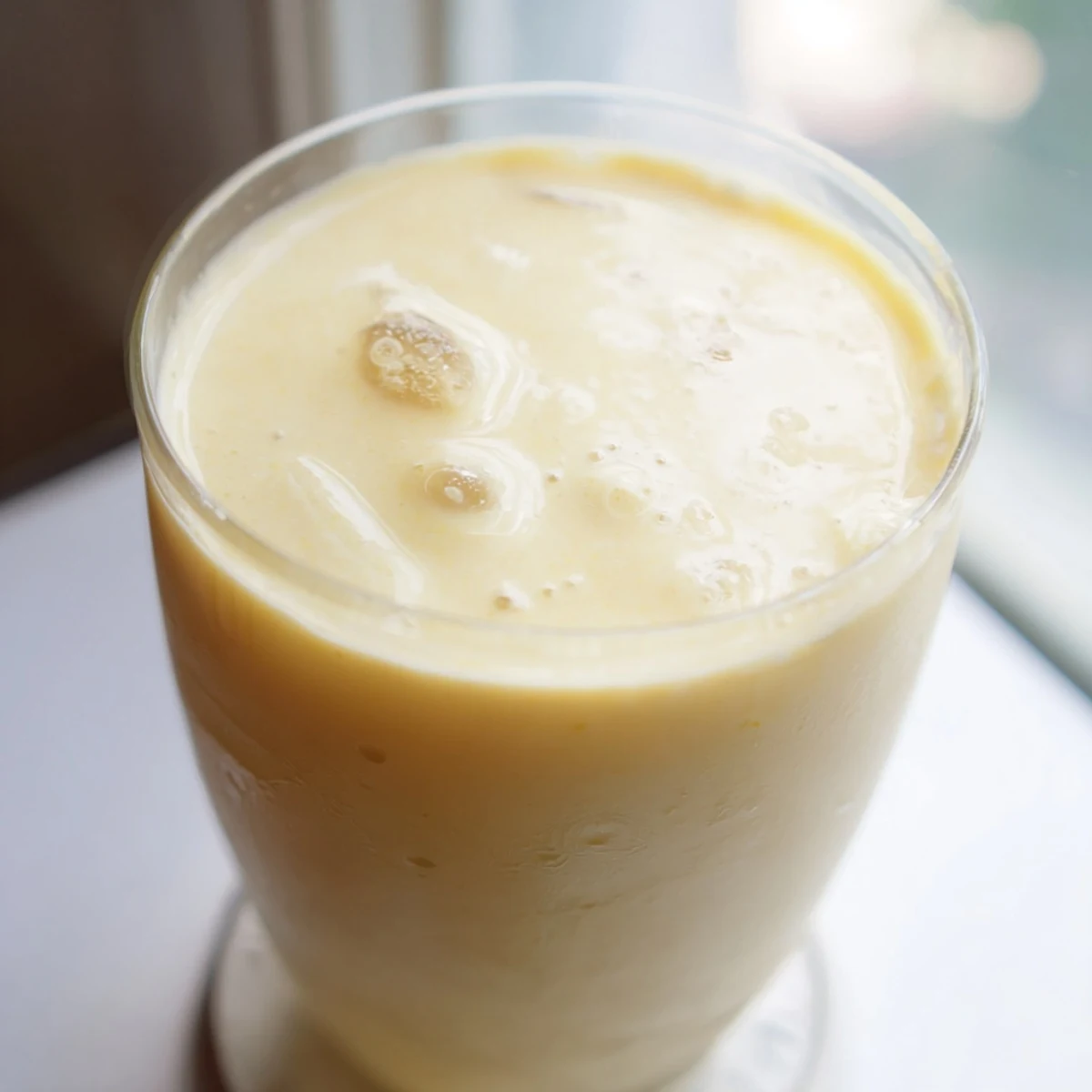 Tropical durian smoothie with ice cubes garnished on a wooden table