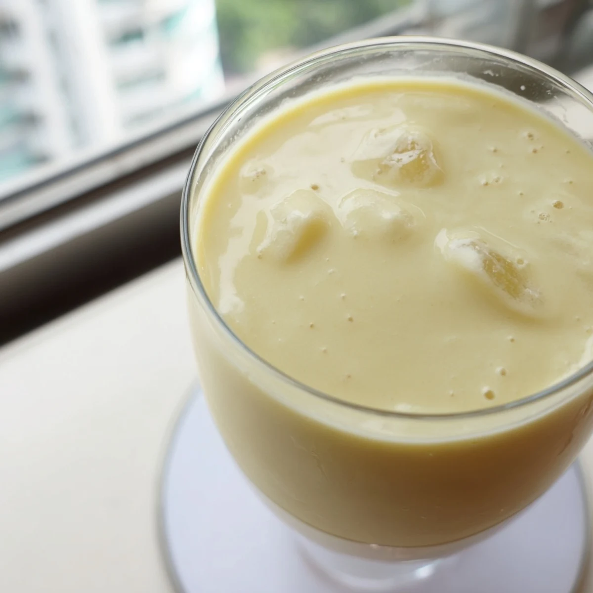Thick durian smoothie poured into tall glasses showcasing its velvety smooth texture