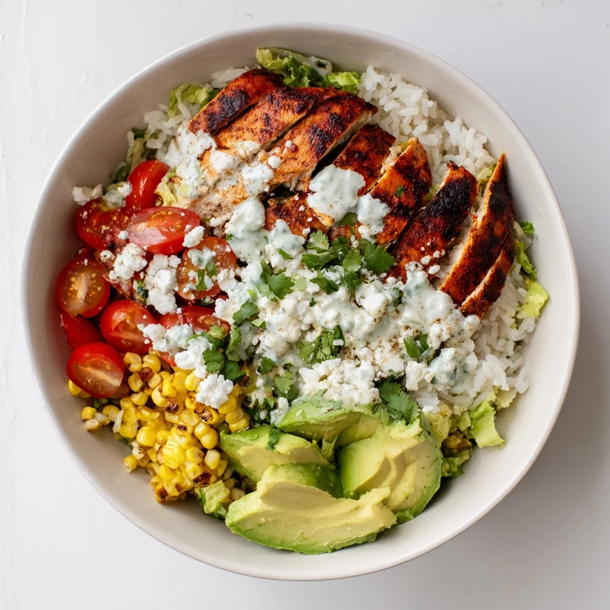 Vibrant Mexican-inspired street corn chicken bowl featuring spiced grilled chicken, charred corn kernels, crisp lettuce, and creamy zesty topping