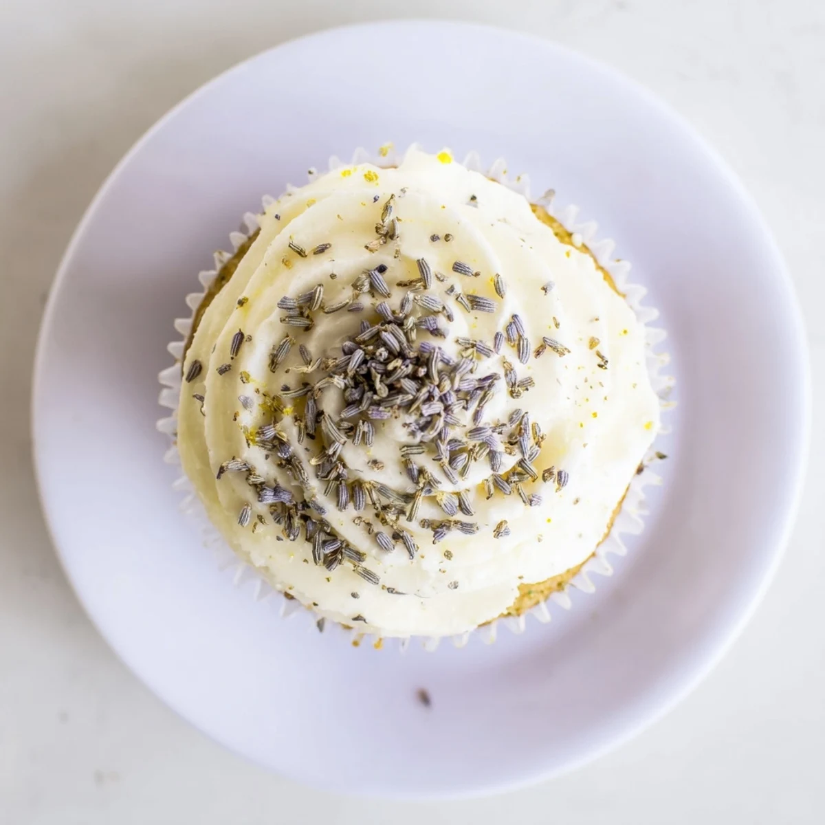 Fresh and fluffy lemon lavender cupcakes topped with creamy white frosting and scattered purple buds
