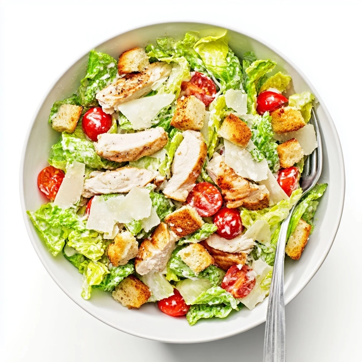 Golden grilled chicken slices rest atop crisp romaine lettuce in this Best Chicken Caesar Salad bowl
