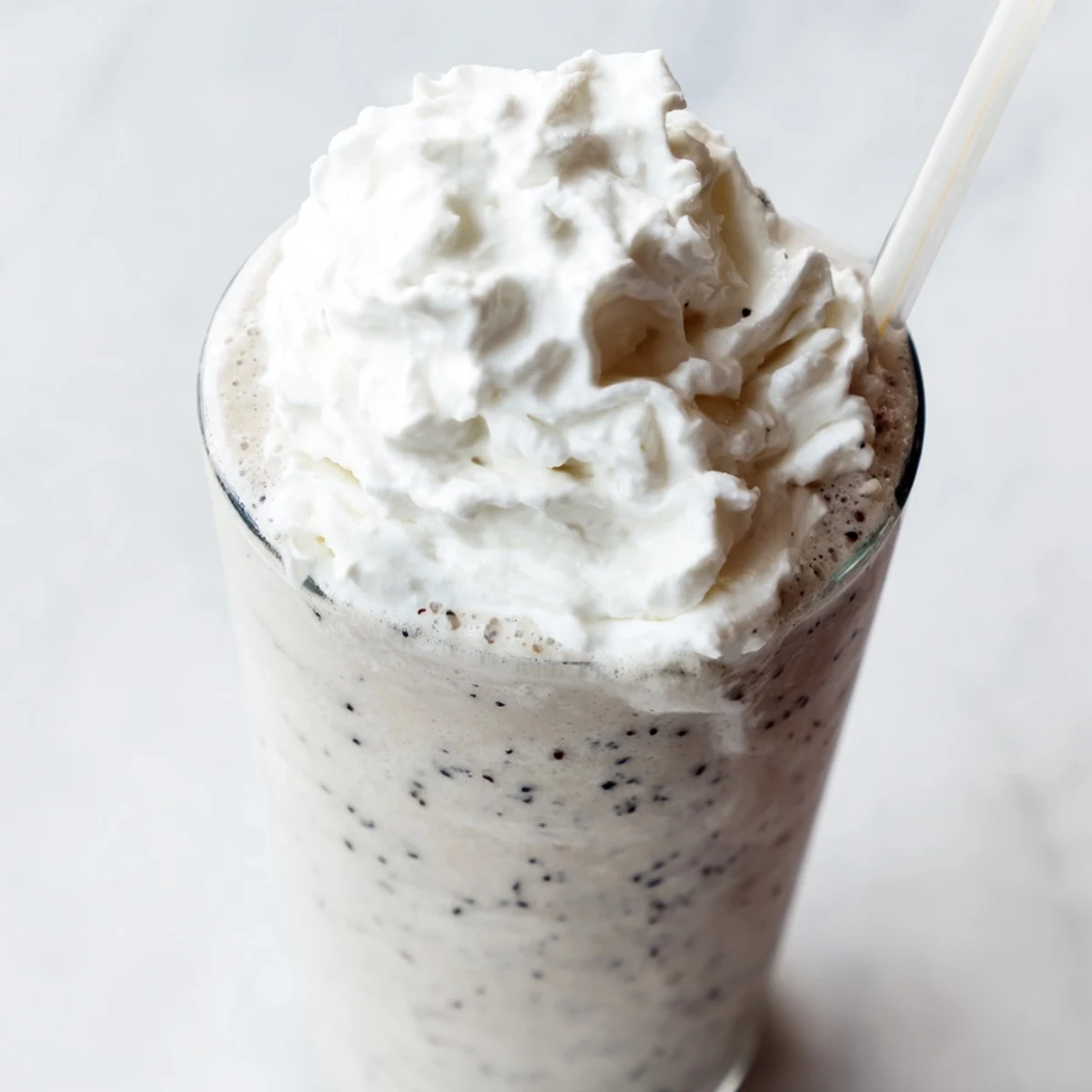 Creamy vanilla bean frappuccino topped with fluffy whipped cream in a chilled glass