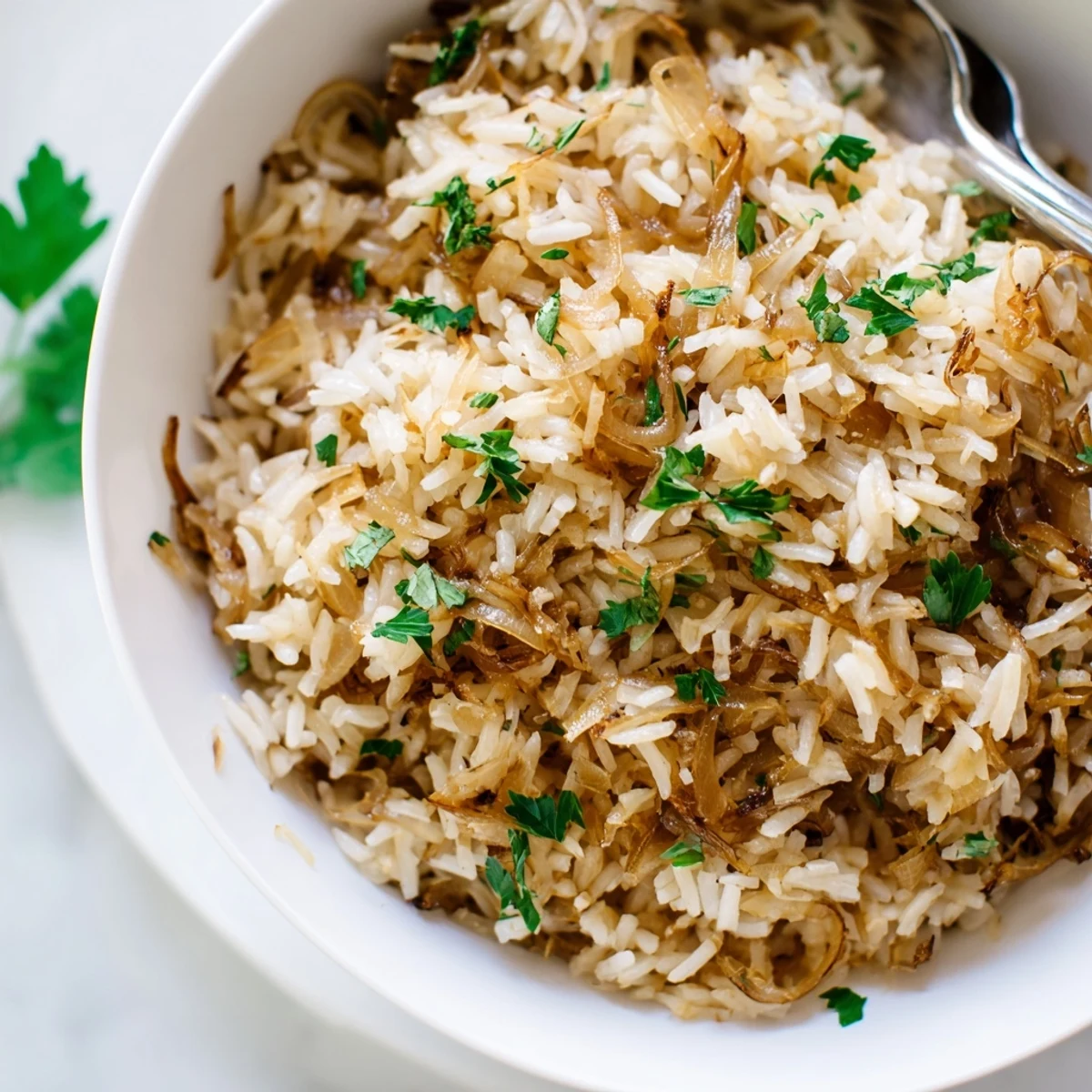 Savory French onion butter rice topped with herbs and cheese served as a comforting vegetarian side dish