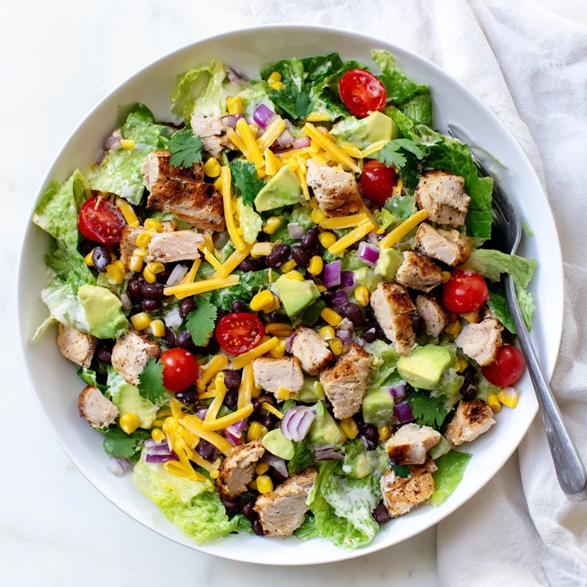 Colorful Healthy BBQ Chicken Chopped Salad bowl with grilled chicken, fresh vegetables, and creamy dressing