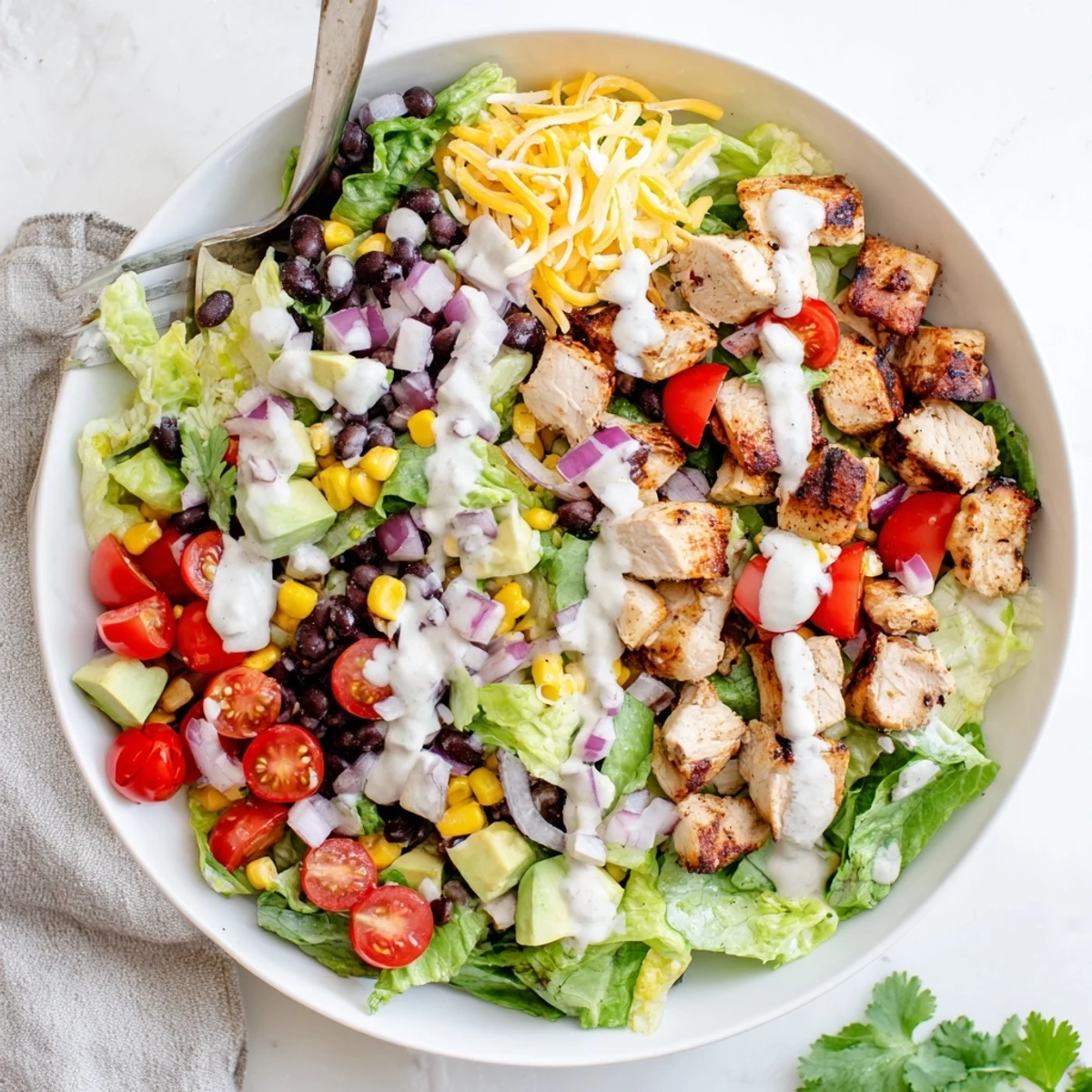 Protein-packed Healthy BBQ Chicken Chopped Salad featuring charred chicken breast over crisp lettuce, corn, beans, and avocado