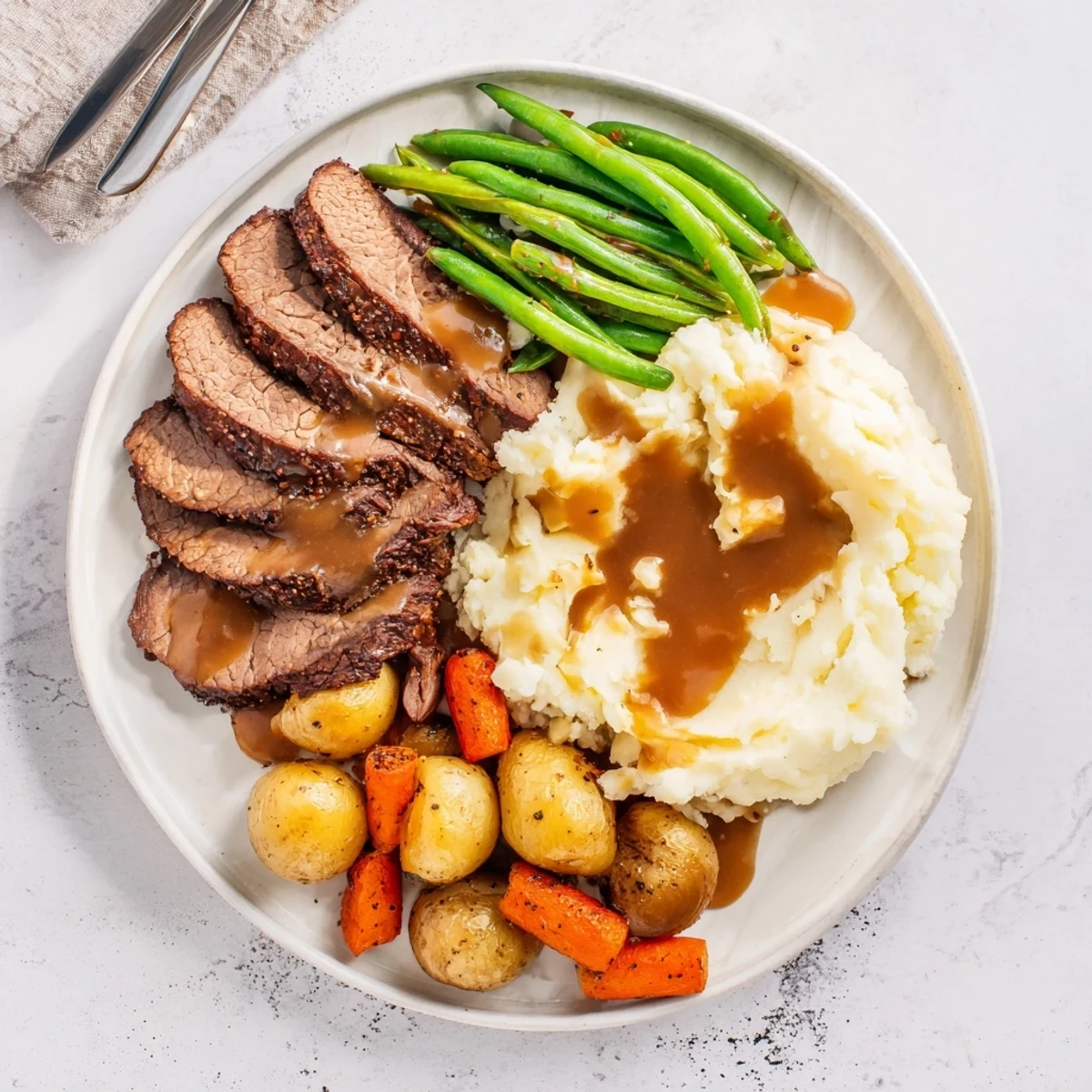 Golden brown Southern style pot roast plate with tender beef, creamy mashed potatoes and fresh green beans