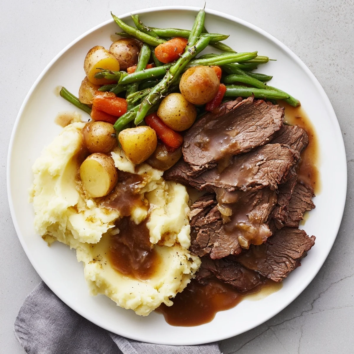 Hearty Southern style pot roast served with rich gravy over mashed potatoes and crisp seasoned green beans
