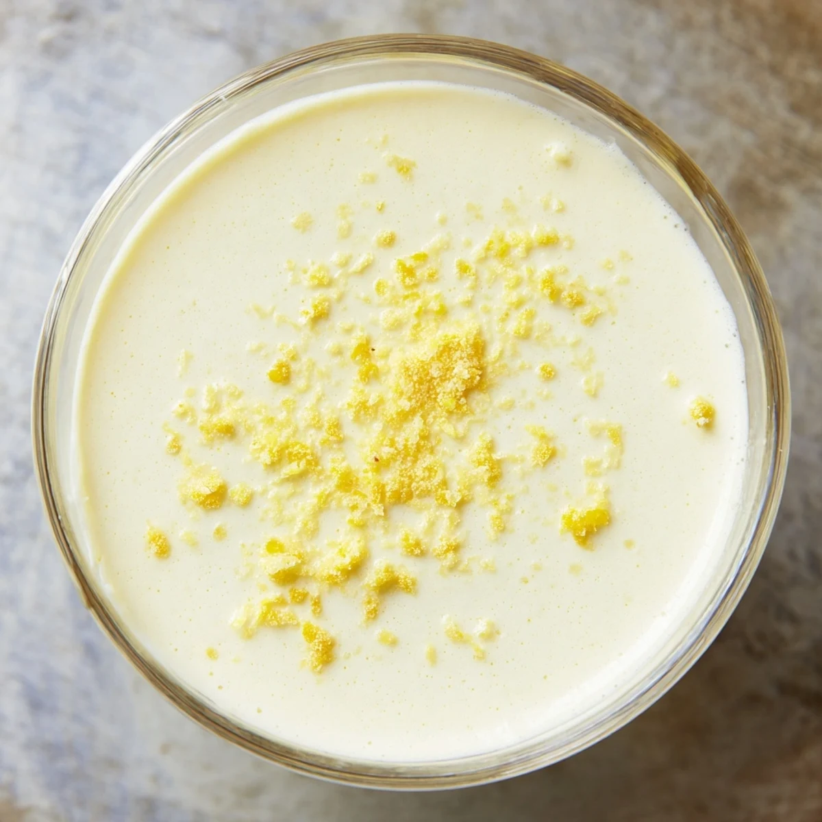 Creamy lemon posset chilled in clear glasses with fresh berry garnish and zest