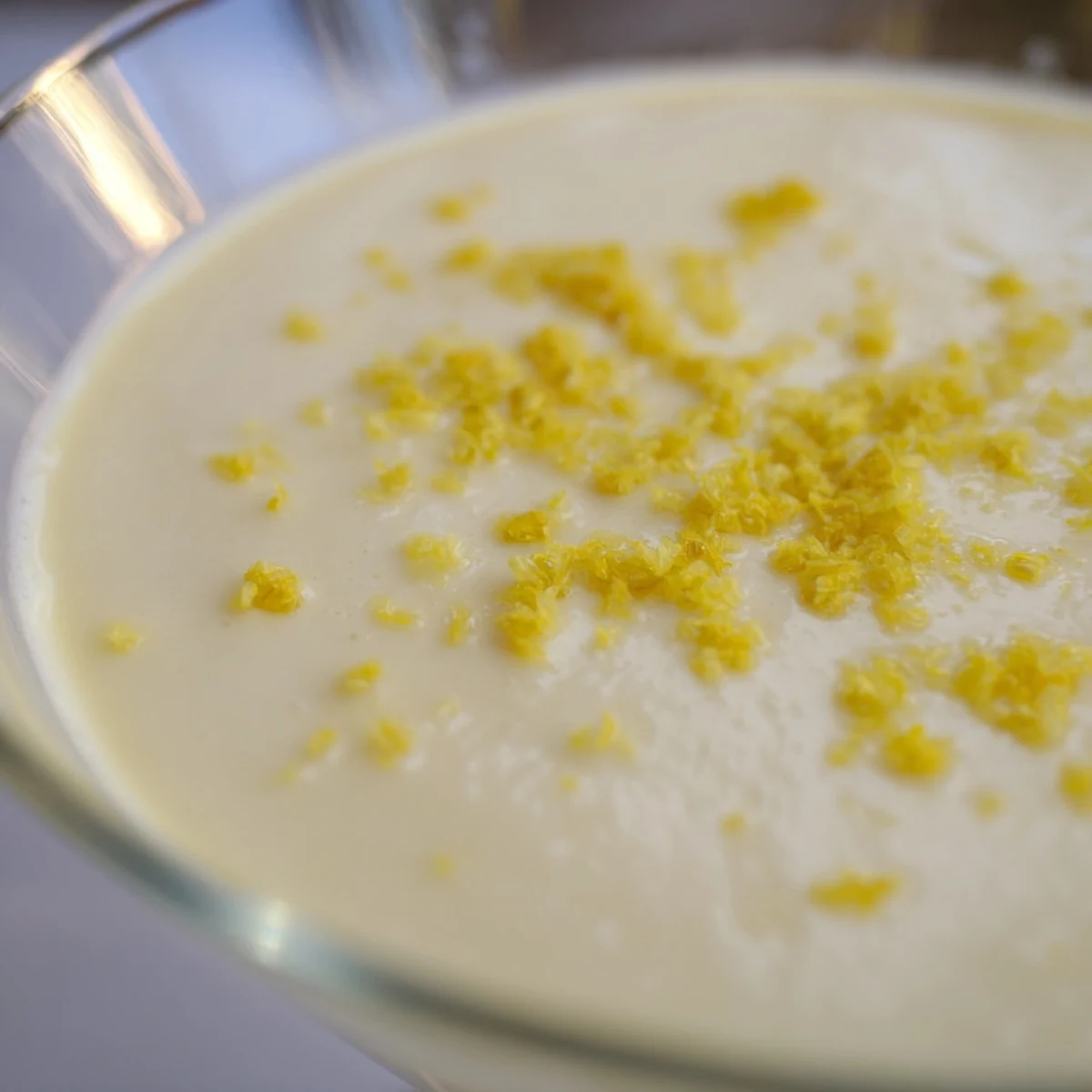 Silky British lemon posset set in white ramekins served with shortbread cookies