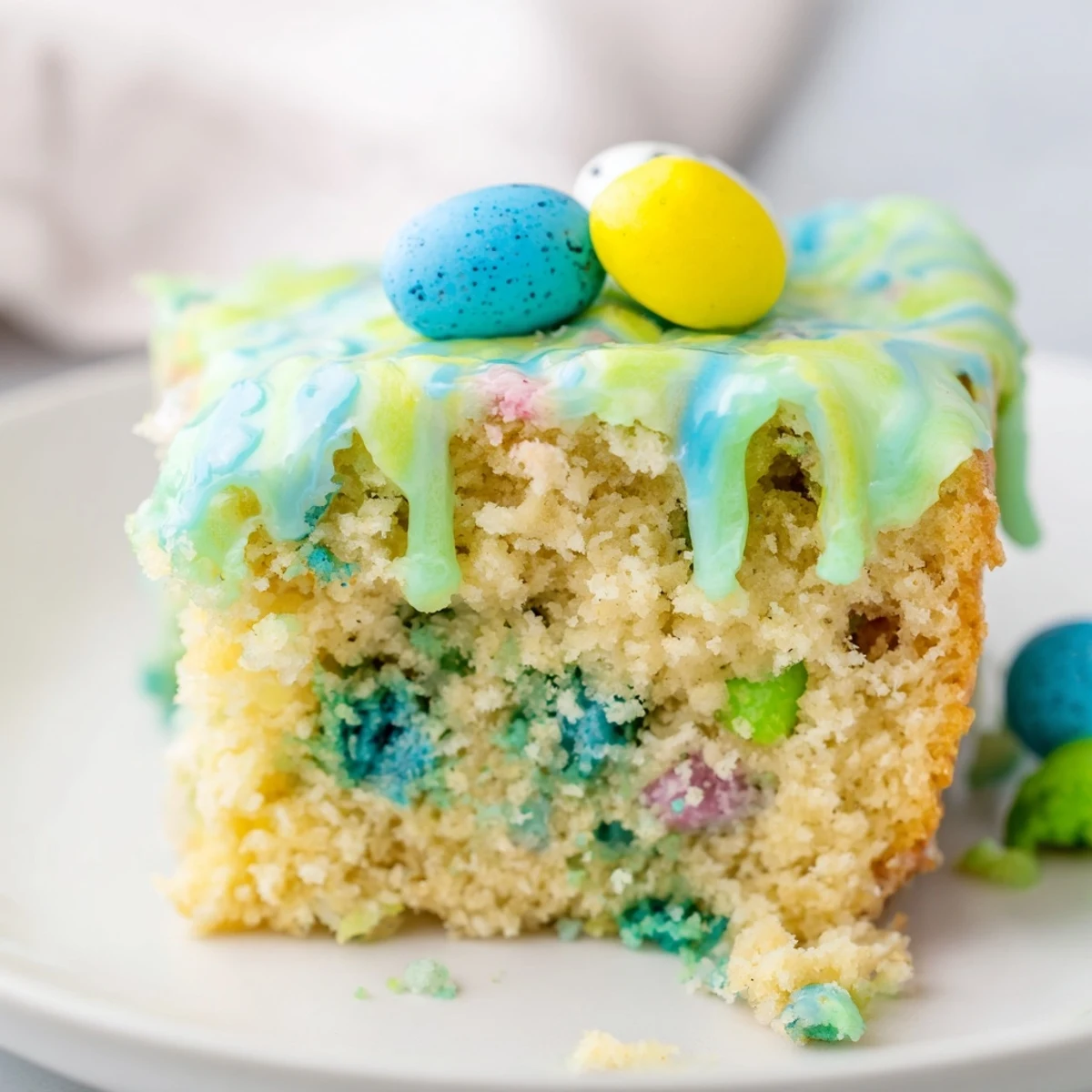 Tender vanilla robin egg snack cake slice showing speckled candy pieces inside fluffy crumb
