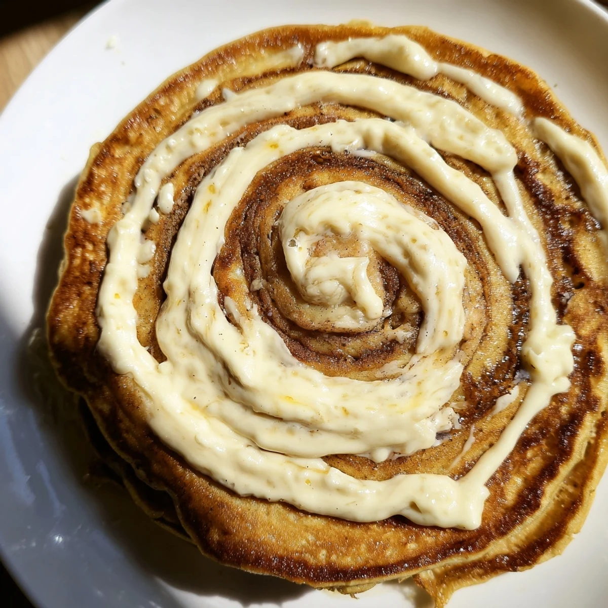 Fluffy breakfast pancakes swirled with warm cinnamon sugar and topped with creamy glaze