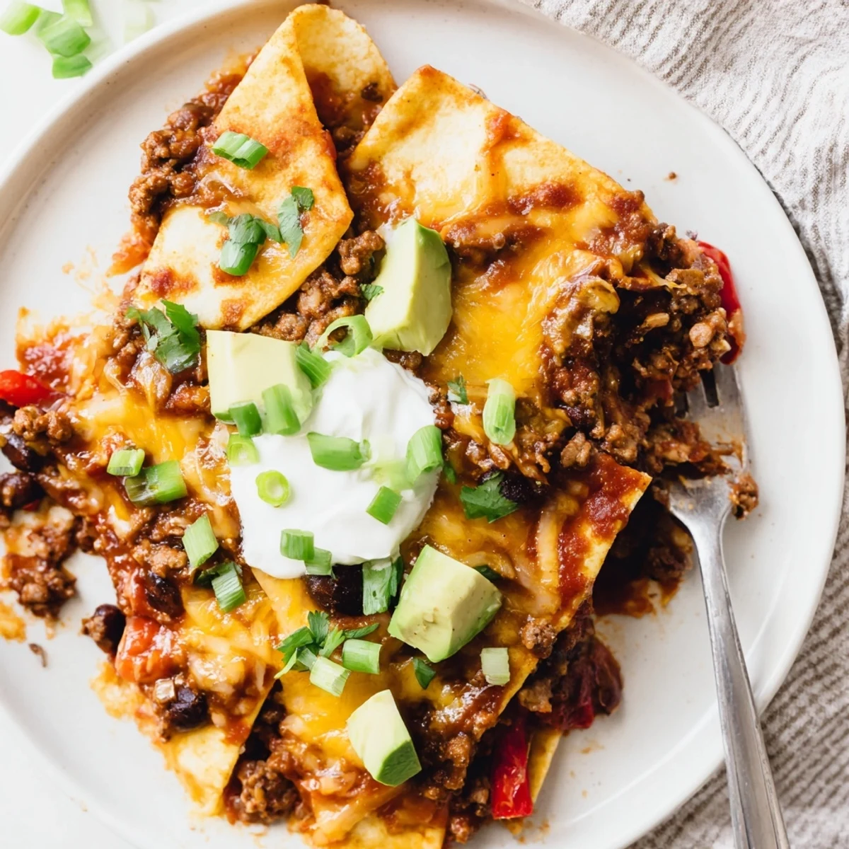 Hearty Beef Skillet Enchiladas served hot with creamy sour cream and avocado