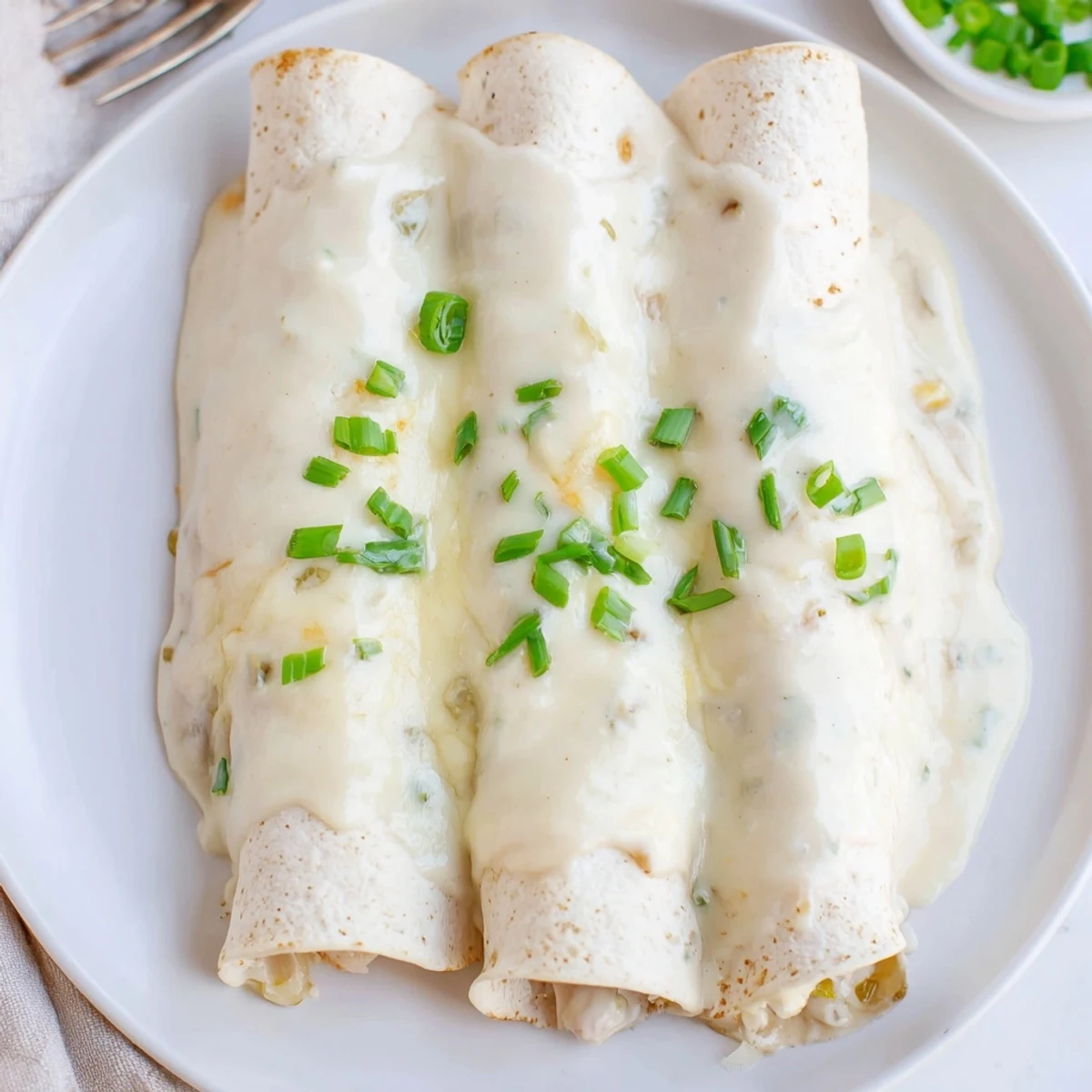 Oven-baked Creamy White Chicken Enchiladas with velvety sauce and tender shredded chicken