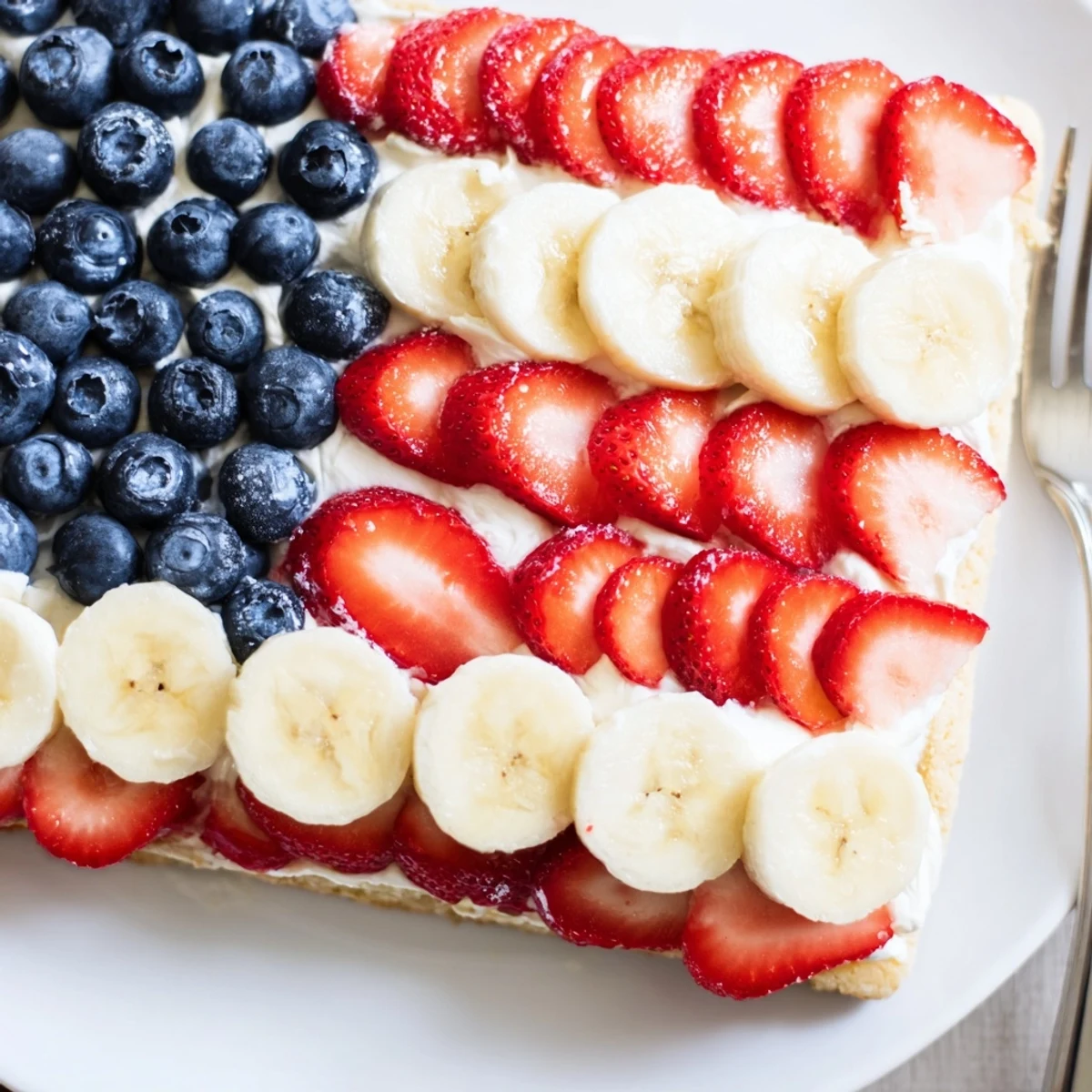 Sliced American Flag Fruit Pizza chilled, vibrant strawberries, bananas, and juicy blueberries