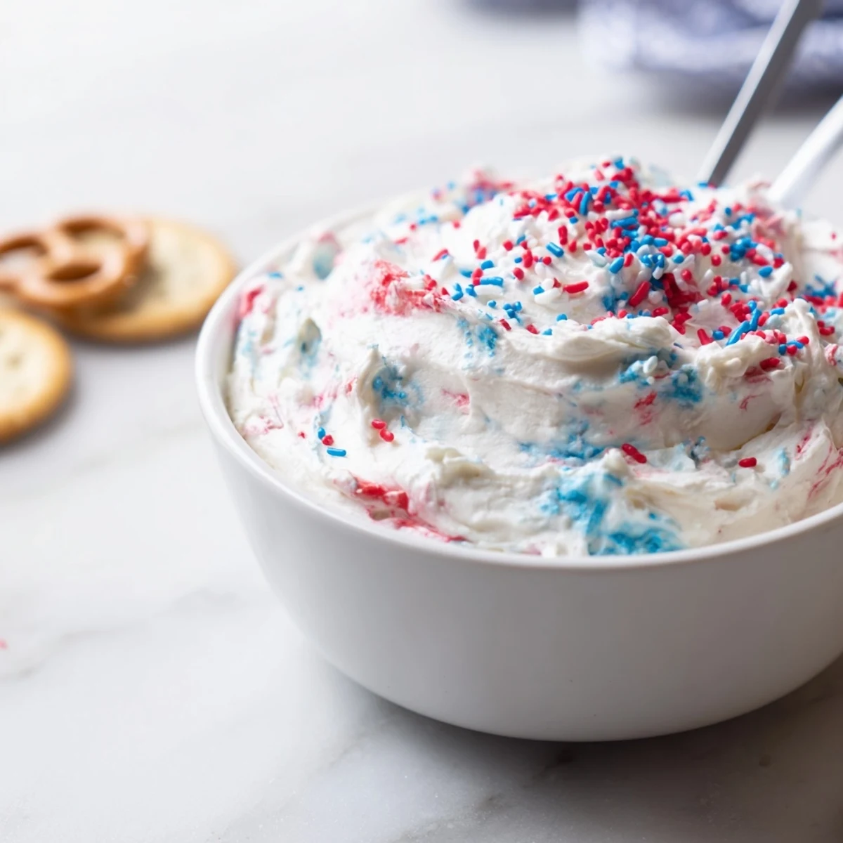 Creamy Red White And Blue Funfetti Dip topped with extra sprinkles and wafers