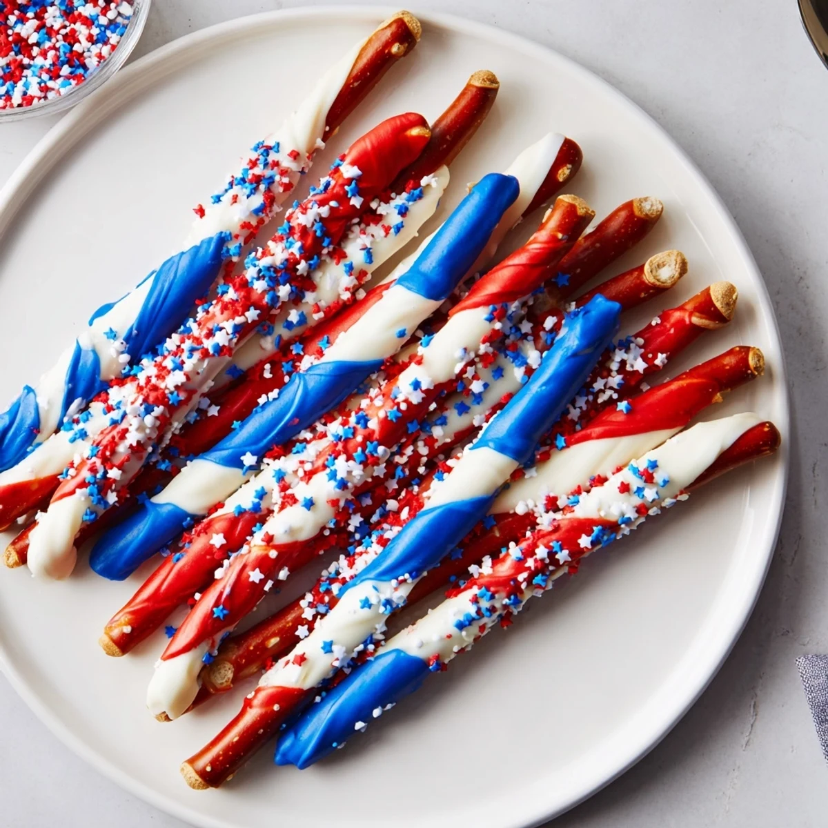 Patriotic Pretzel Rods with glossy white chocolate and crunchy red, blue sprinkles